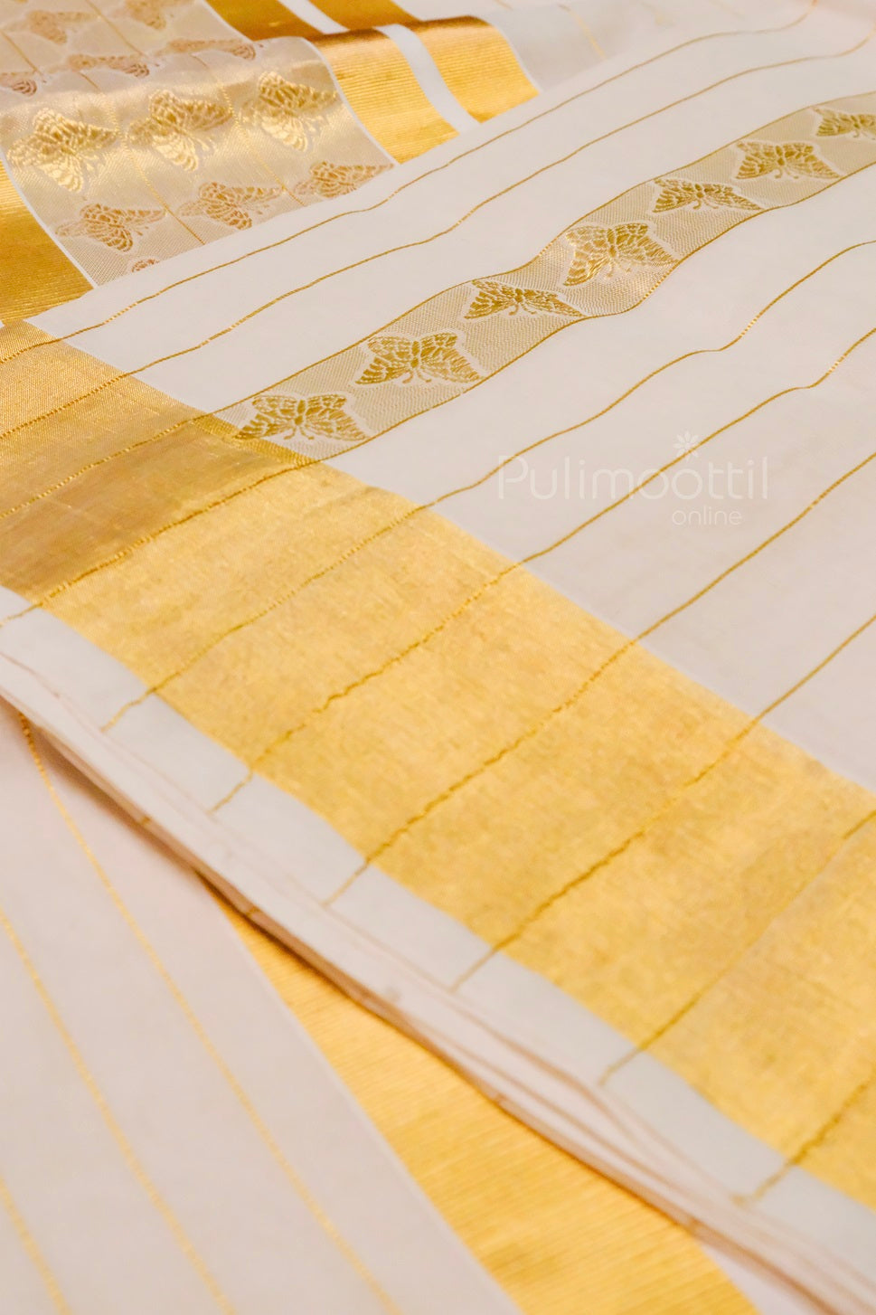 Kerala kasavu saree end portion (pallu) with thick gold zari border, delicate butterfly motifs, and gold tassels.
