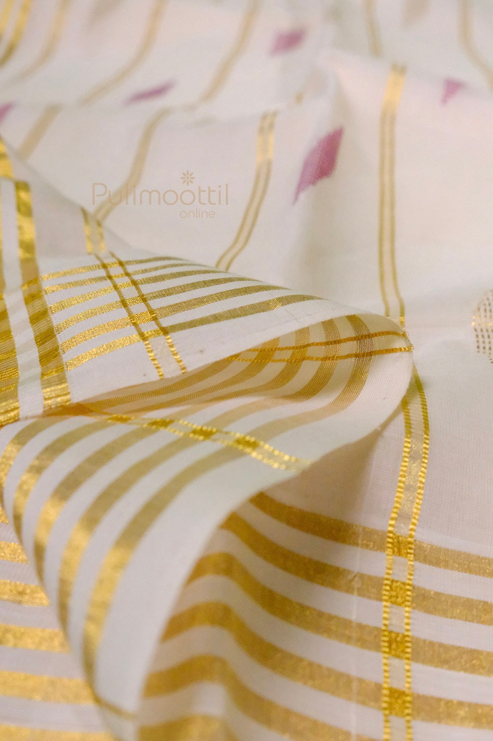Close-up of golden zari stripes and pink motifs on traditional off-white Kerala kasavu saree