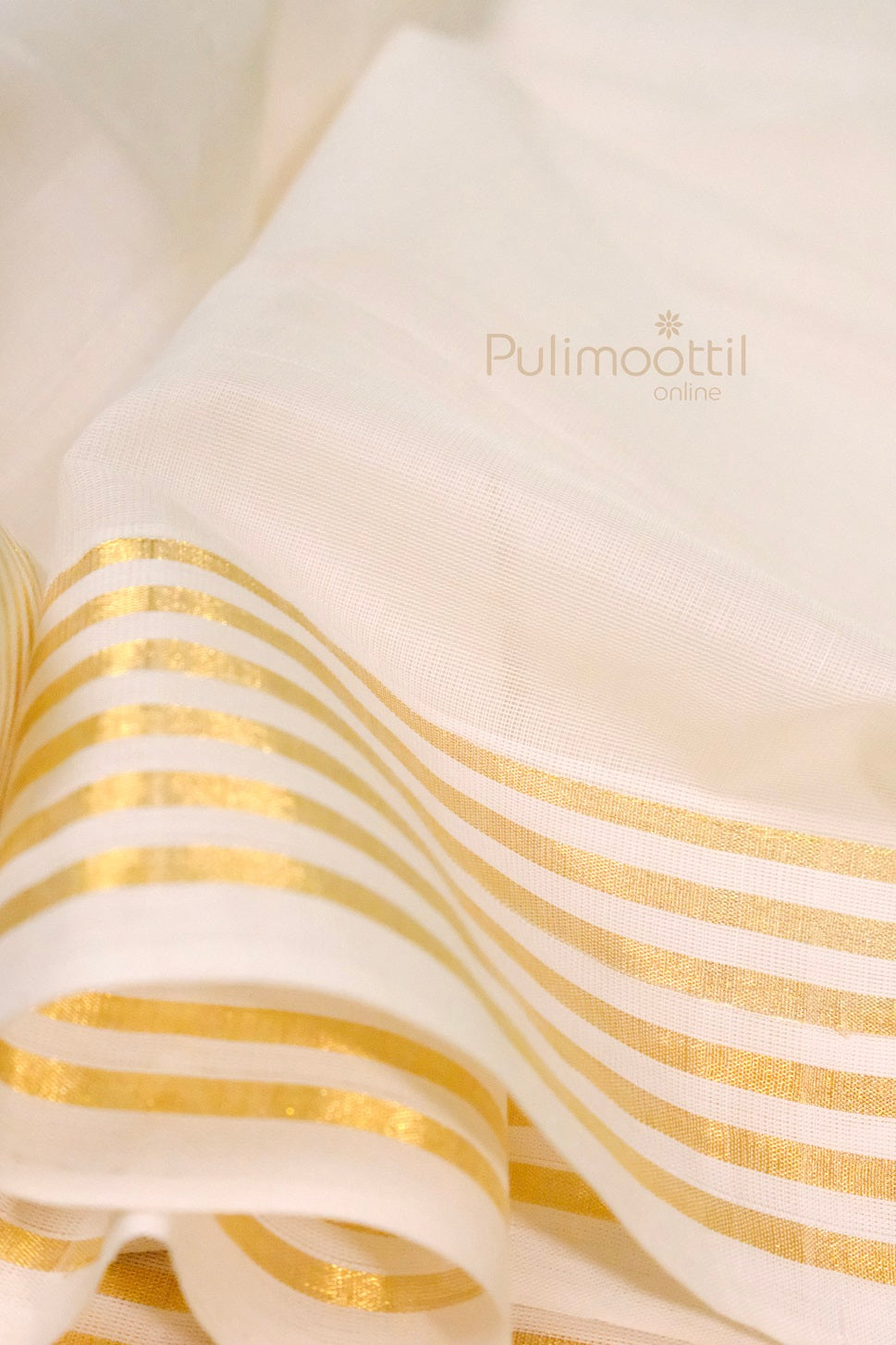 Soft cotton fabric of Kerala kasavu saree with shimmering gold stripes and rich border design