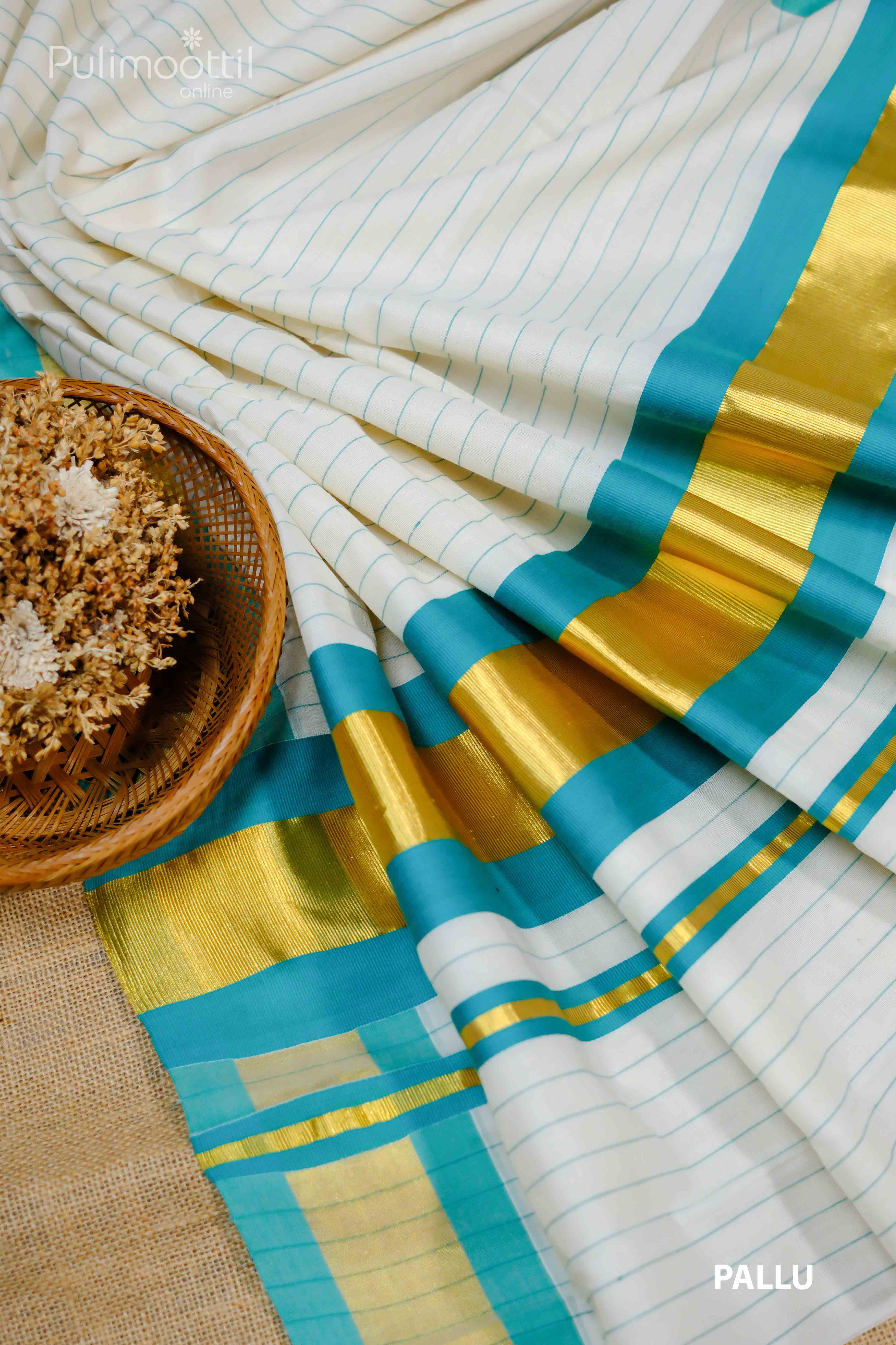 "Pleats of a cream‑white Kerala saree showing scattered peach and blue thread motifs, with a matching peach and deep‑blue striped border.