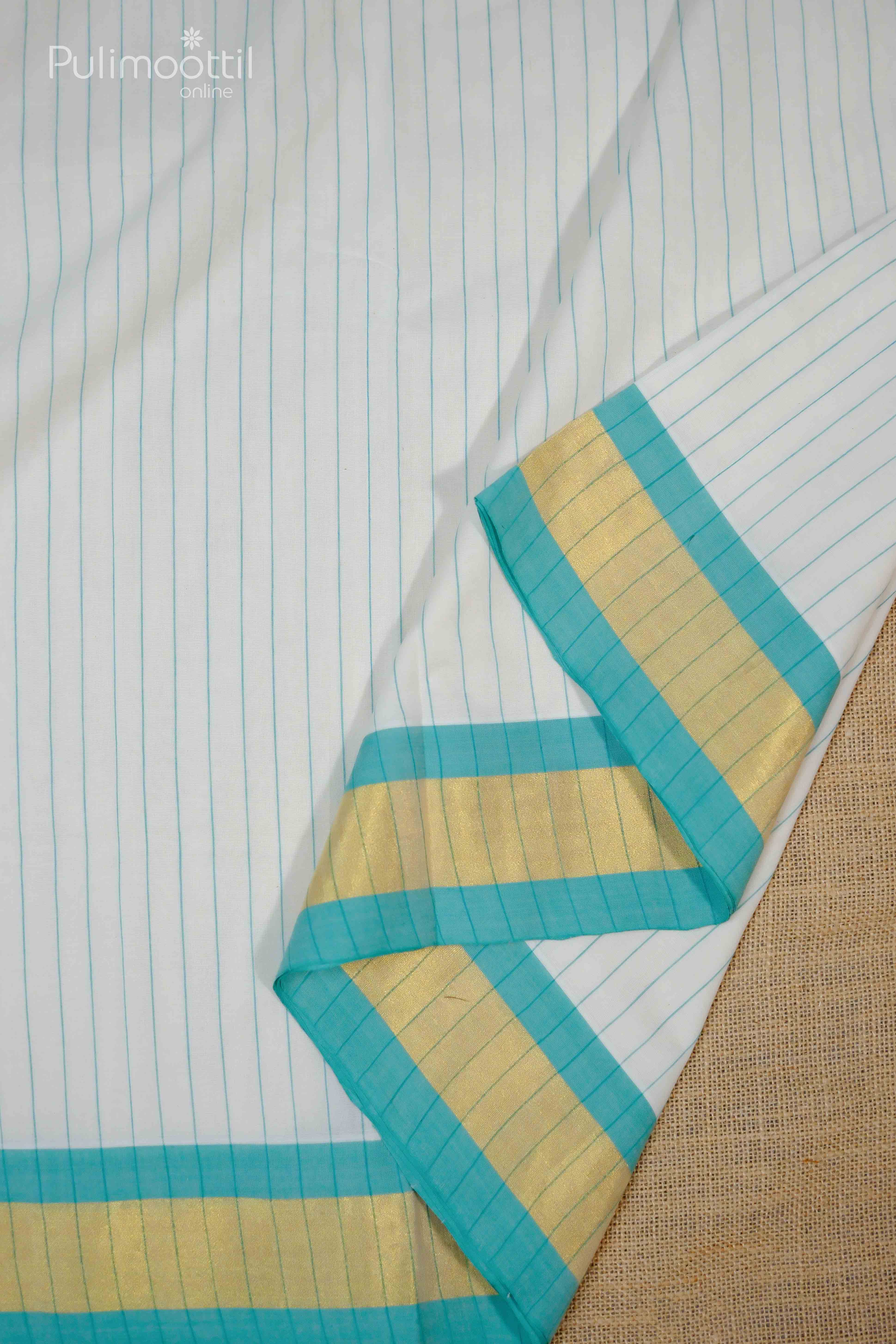Cream‑white blouse draped on a mannequin shoulder, trimmed with peach and deep‑blue stripes along the neckline, showcasing fine cotton weave.