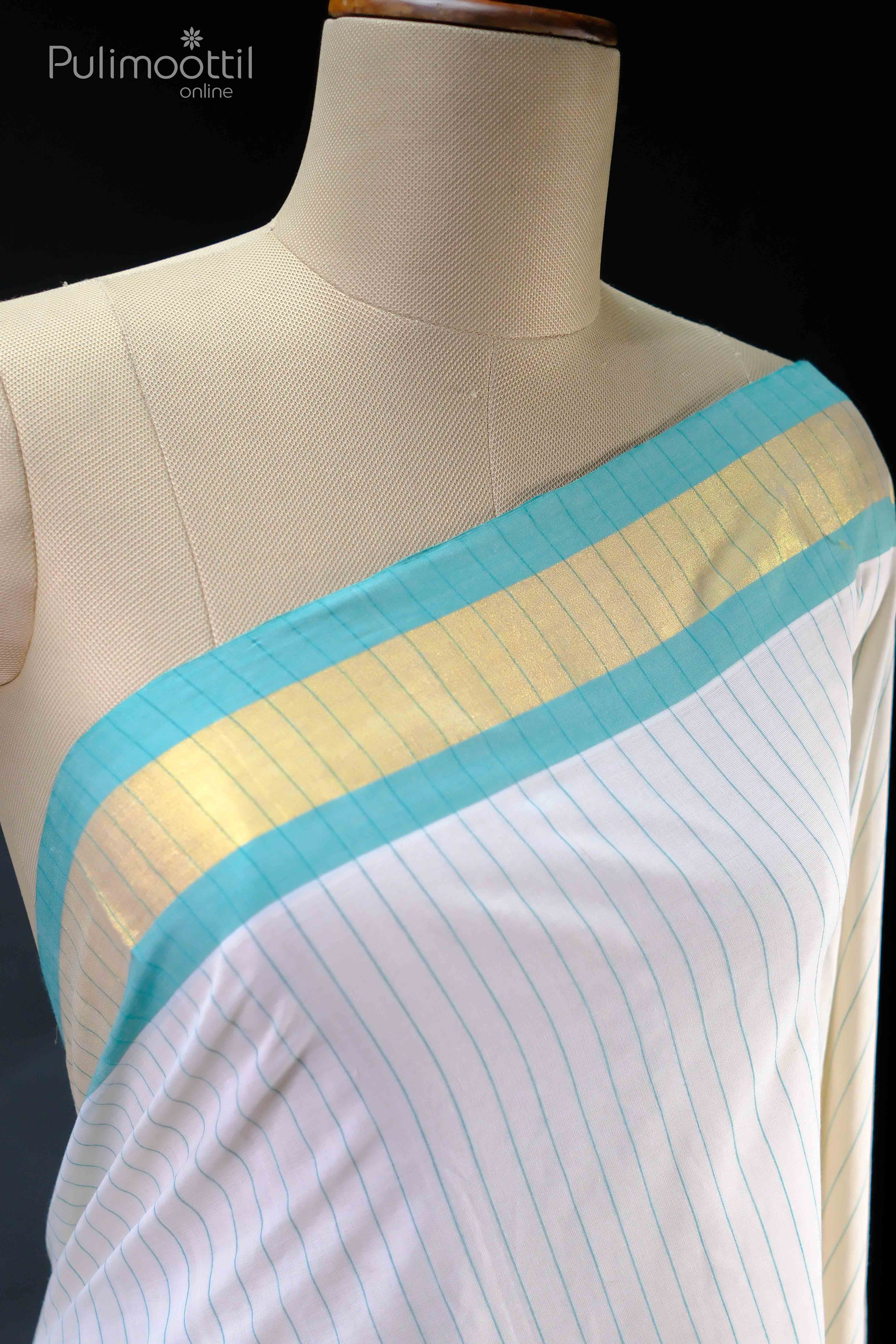 Cream‑white handloom Kerala tissue saree blouse draped on a mannequin, showcasing aqua‑blue pinstripes and a lustrous gold‑tissue border along the neckline.