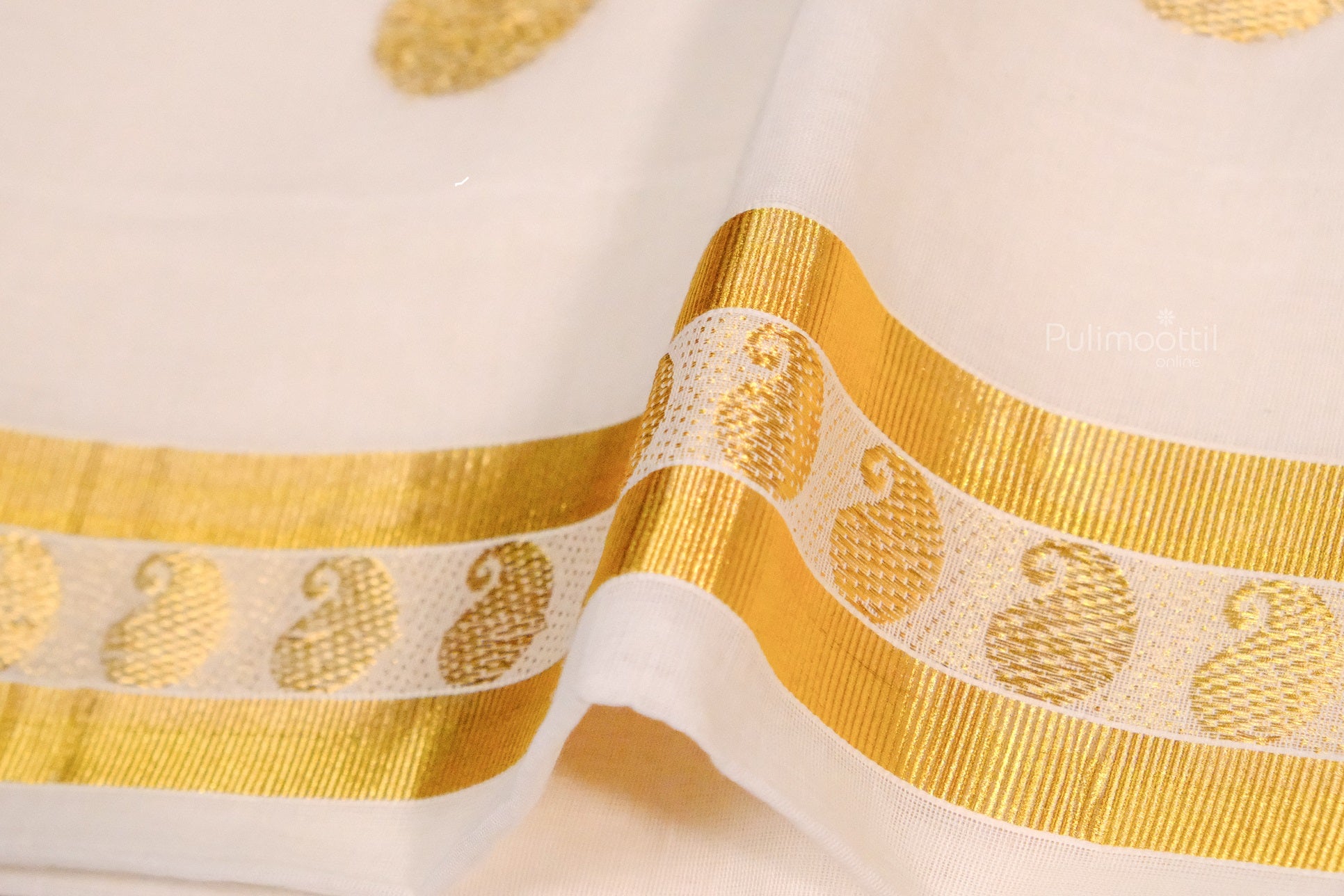 Golden zari border with recurring paisley motifs on a traditional Kerala kasavu saree, showcasing intricate weaving.