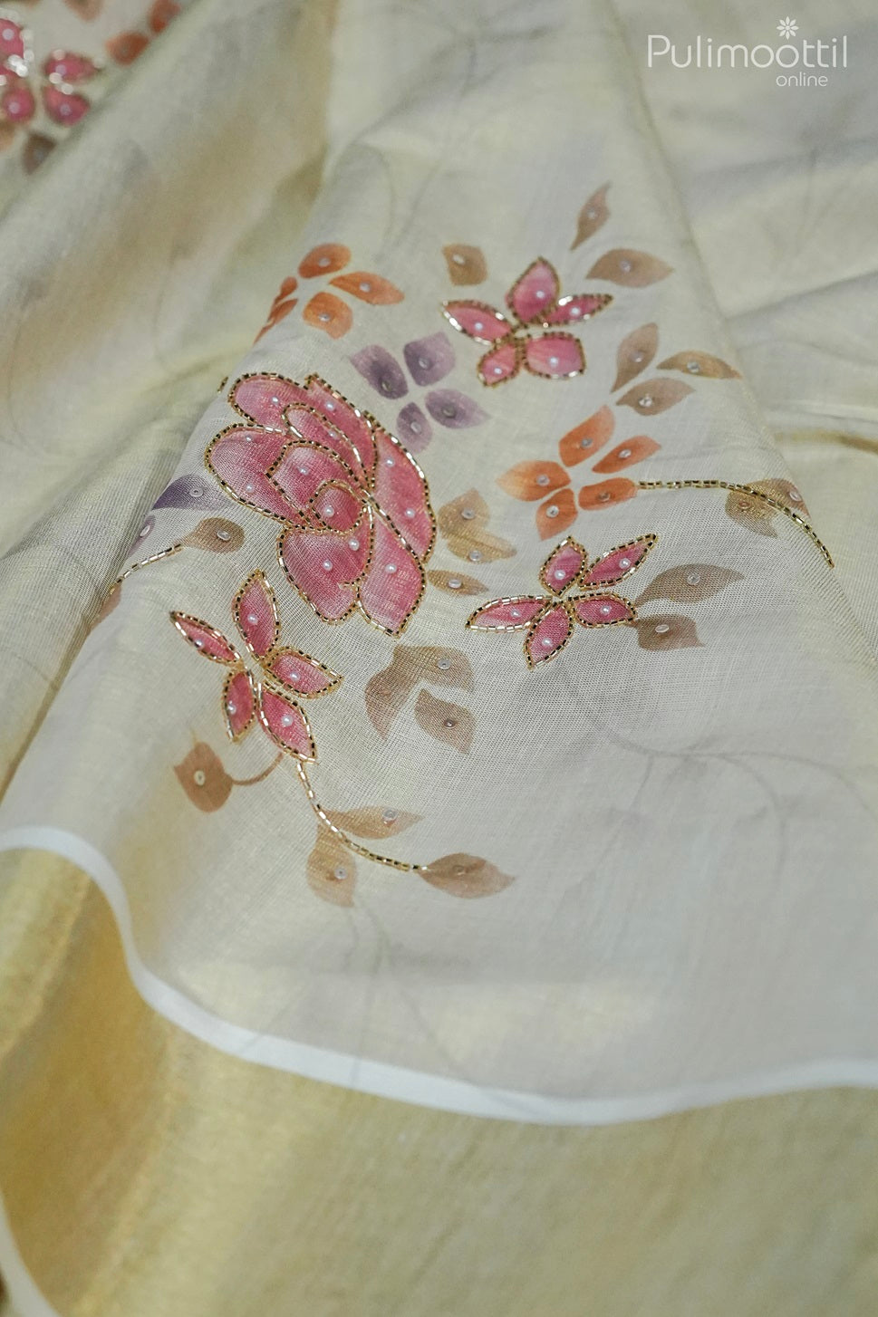 Close-up of floral printed body with pink and orange flowers, bead and sequence work on Kerala traditional tissue saree