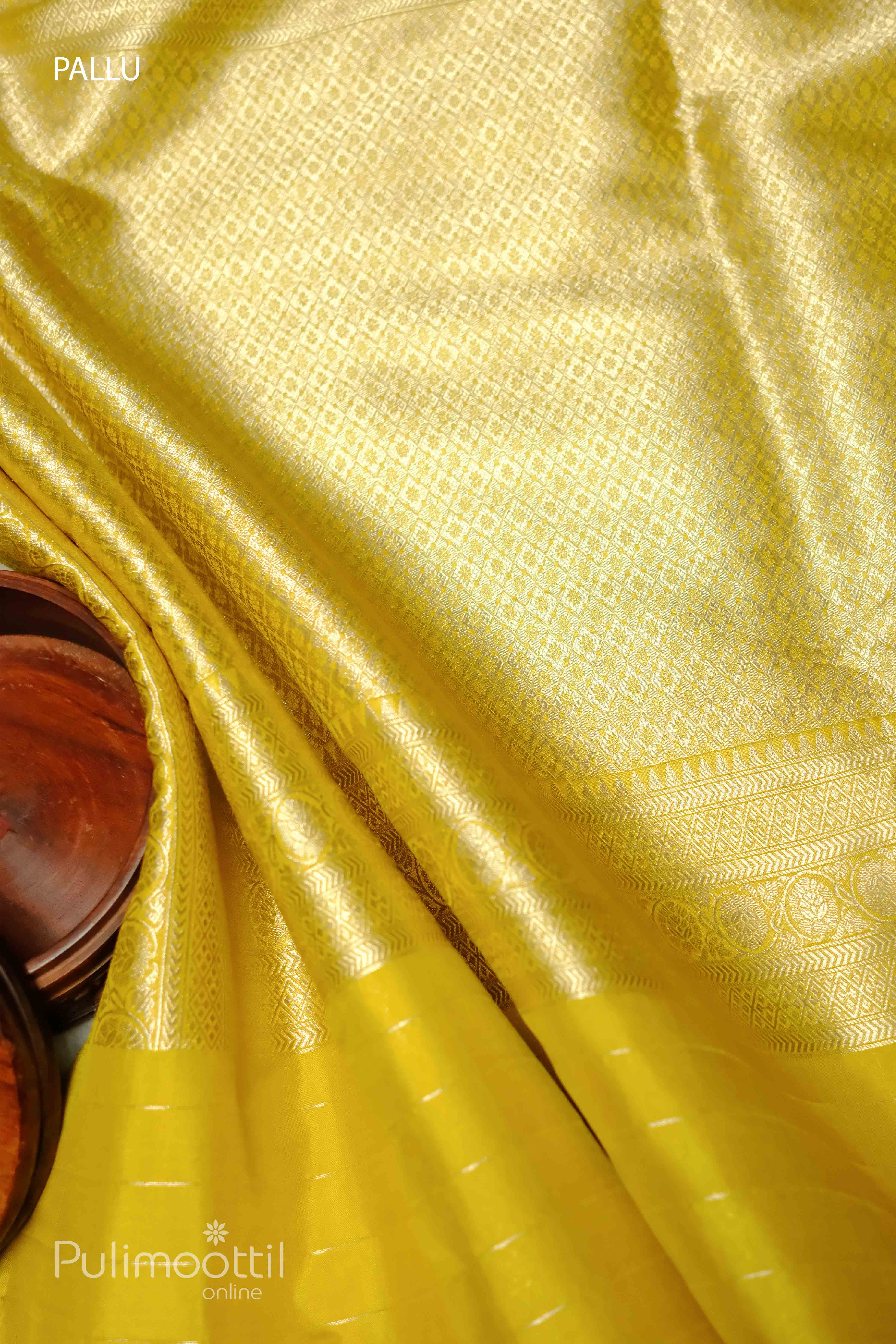 Lemon yellow pure Banarasi silk saree with intricate woven floral patterns on the pallu, complemented by a golden border, perfect for weddings and special occasions.