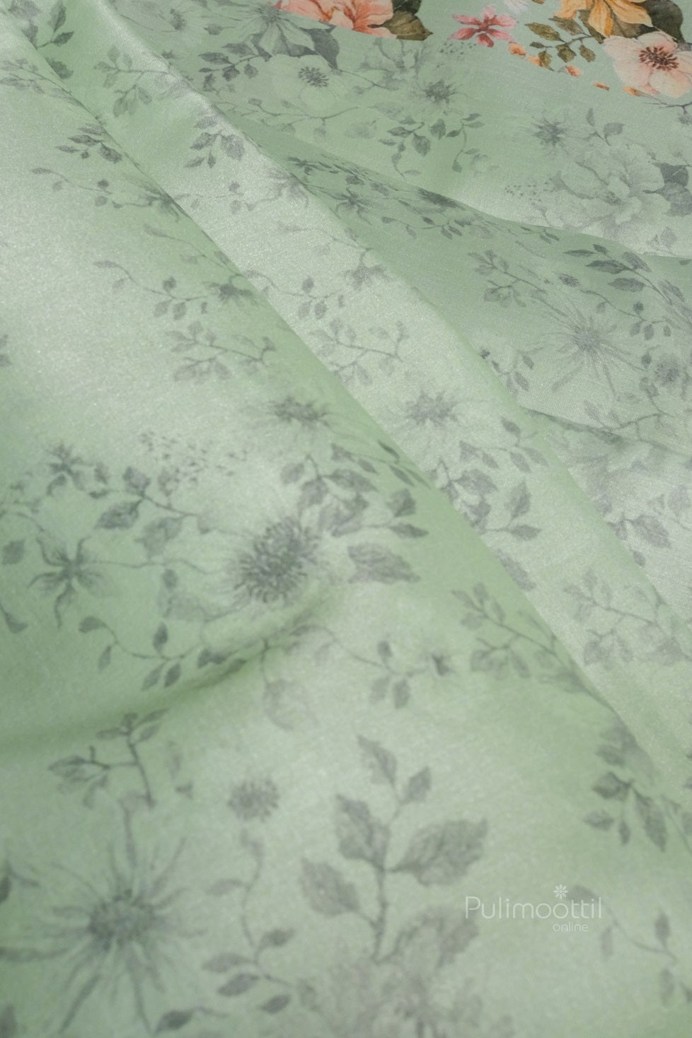 Flat-lay of silk saree showing both pleats and pallu, emphasizing fabric softness and light cyan tone. Subtle decorative motifs visible.