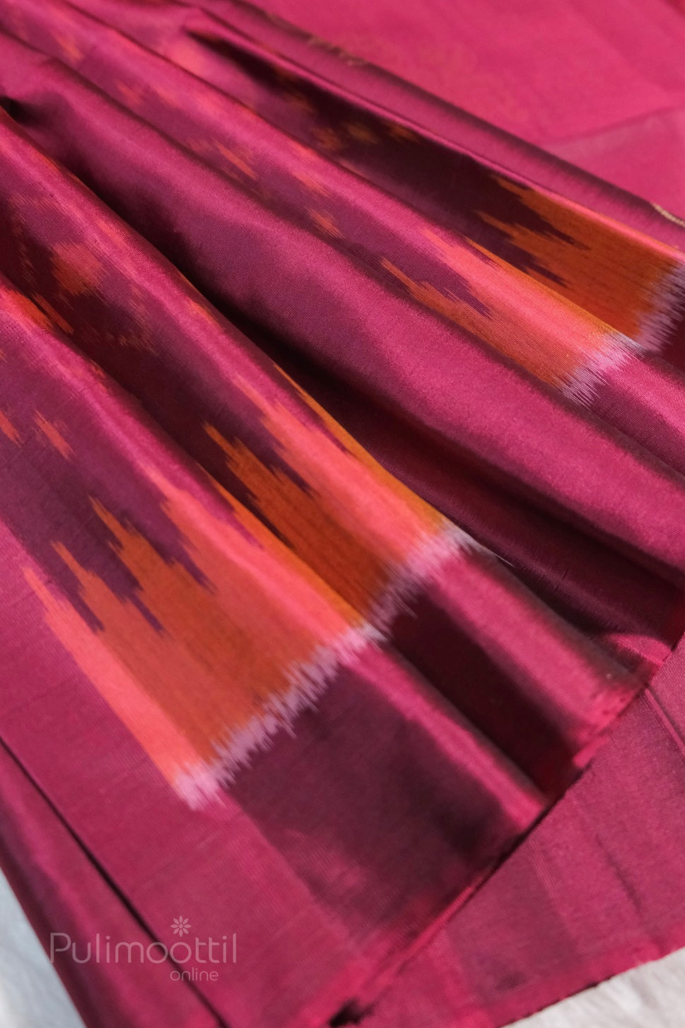 Magenta-pink Kanchipuram soft silk featuring ikkat pattern in tones of orange and pink