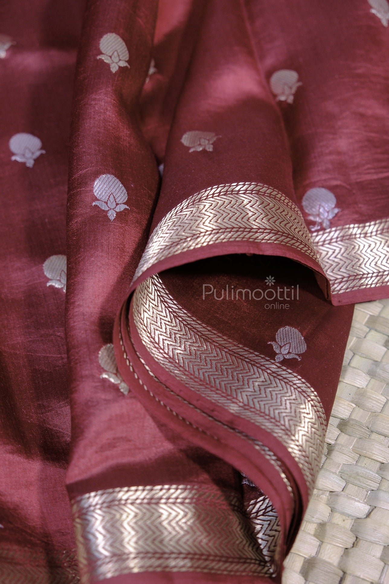 Elegant shot of the cobalt blue mango silk saree showcasing silver zari floral motifs and shimmering chevron pattern border.