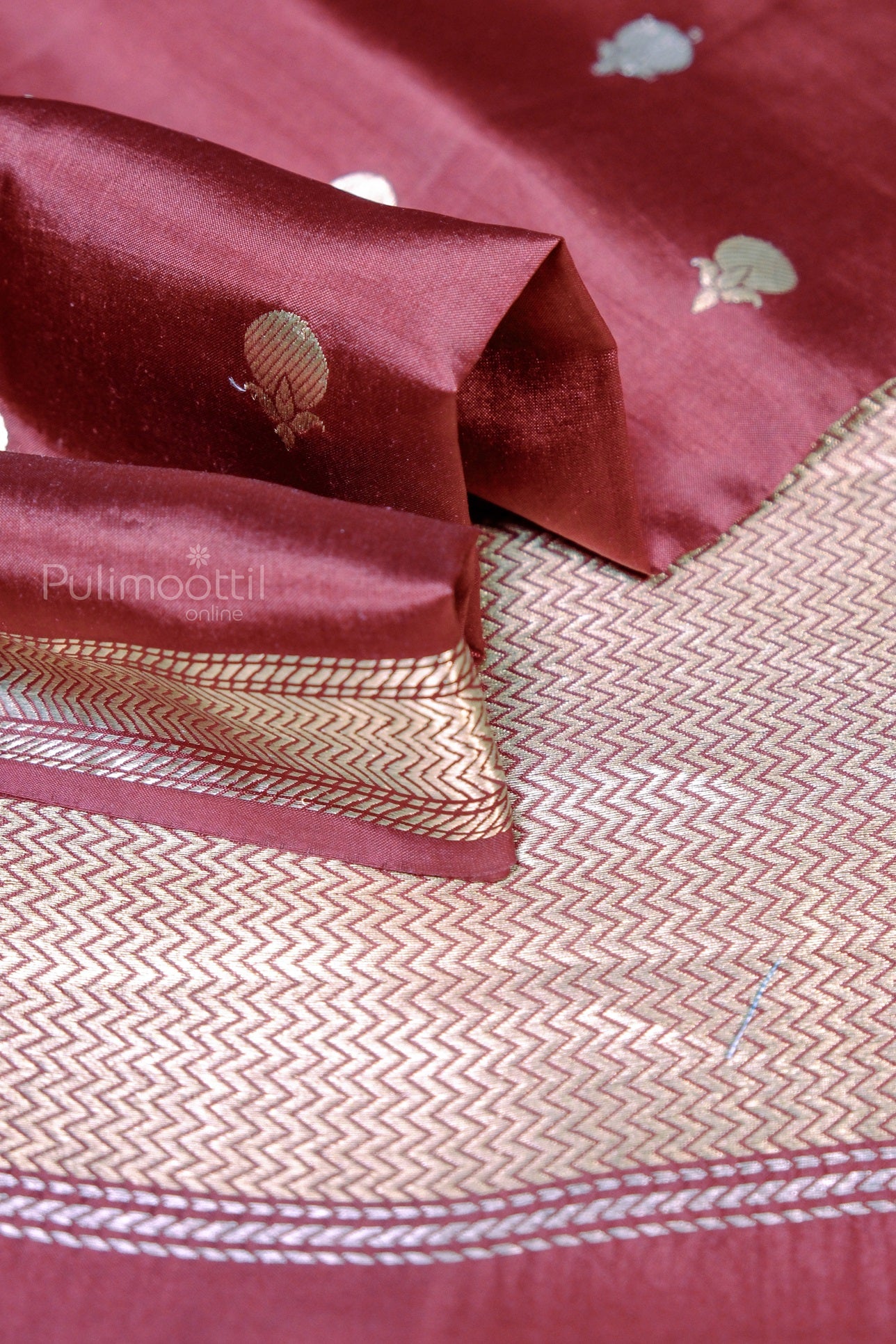 Maroon Kerala handloom saree with intricate gold zari border and traditional woven pallu design – perfect for Onam and festive wear