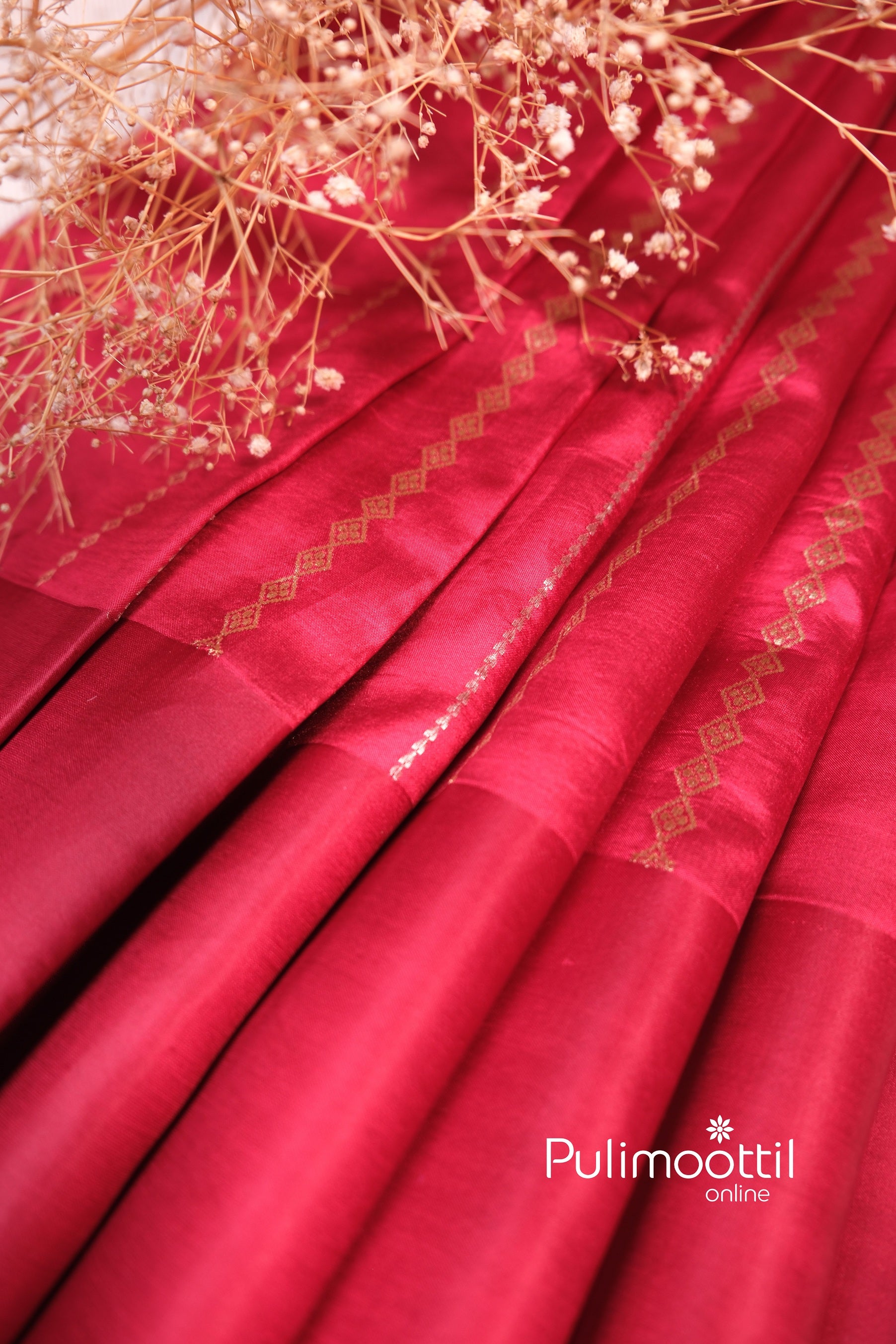 Pleats of the maroon mango silk saree arranged aesthetically, highlighting the sheen of silk and vertical diamond-shaped zari design aligned along the folds.
