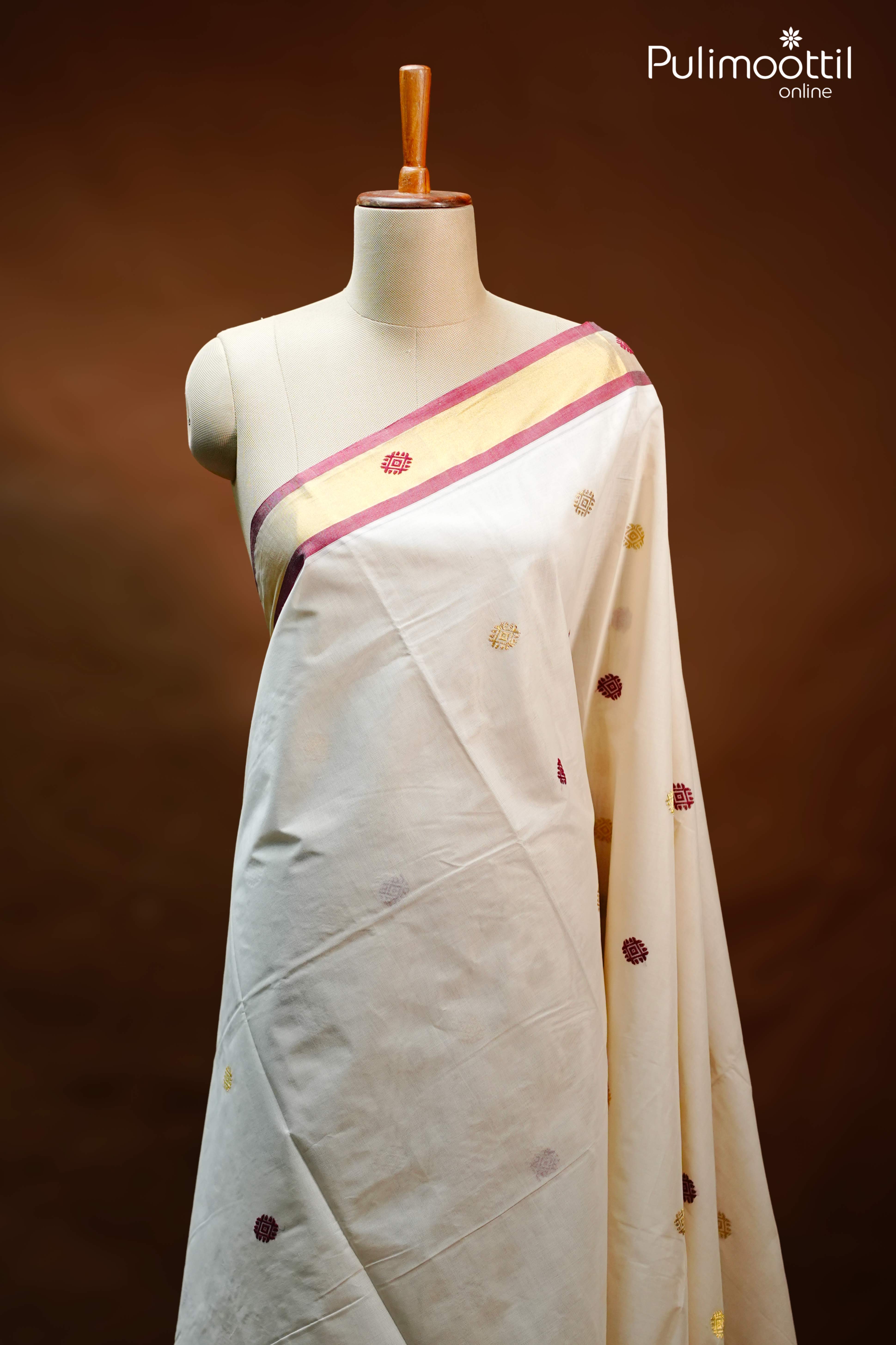 Off White Kerala Set Saree with mixed zari motifs on the body, elegant golden tissue border with maroon edging, draped on a mannequin.