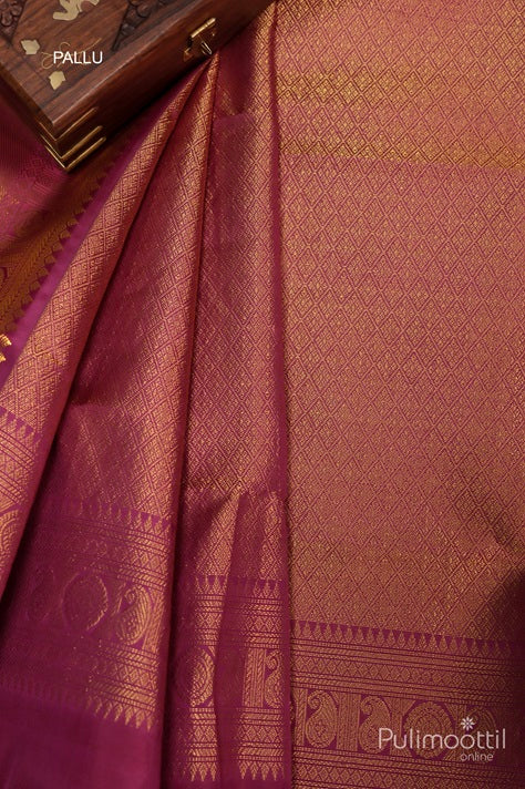 Close-up of Pallu of Off White Kanchipuram Silk Saree with Golden Zari Patterns and Maroon Contrast Border, with Decorative Wooden Box in Background.