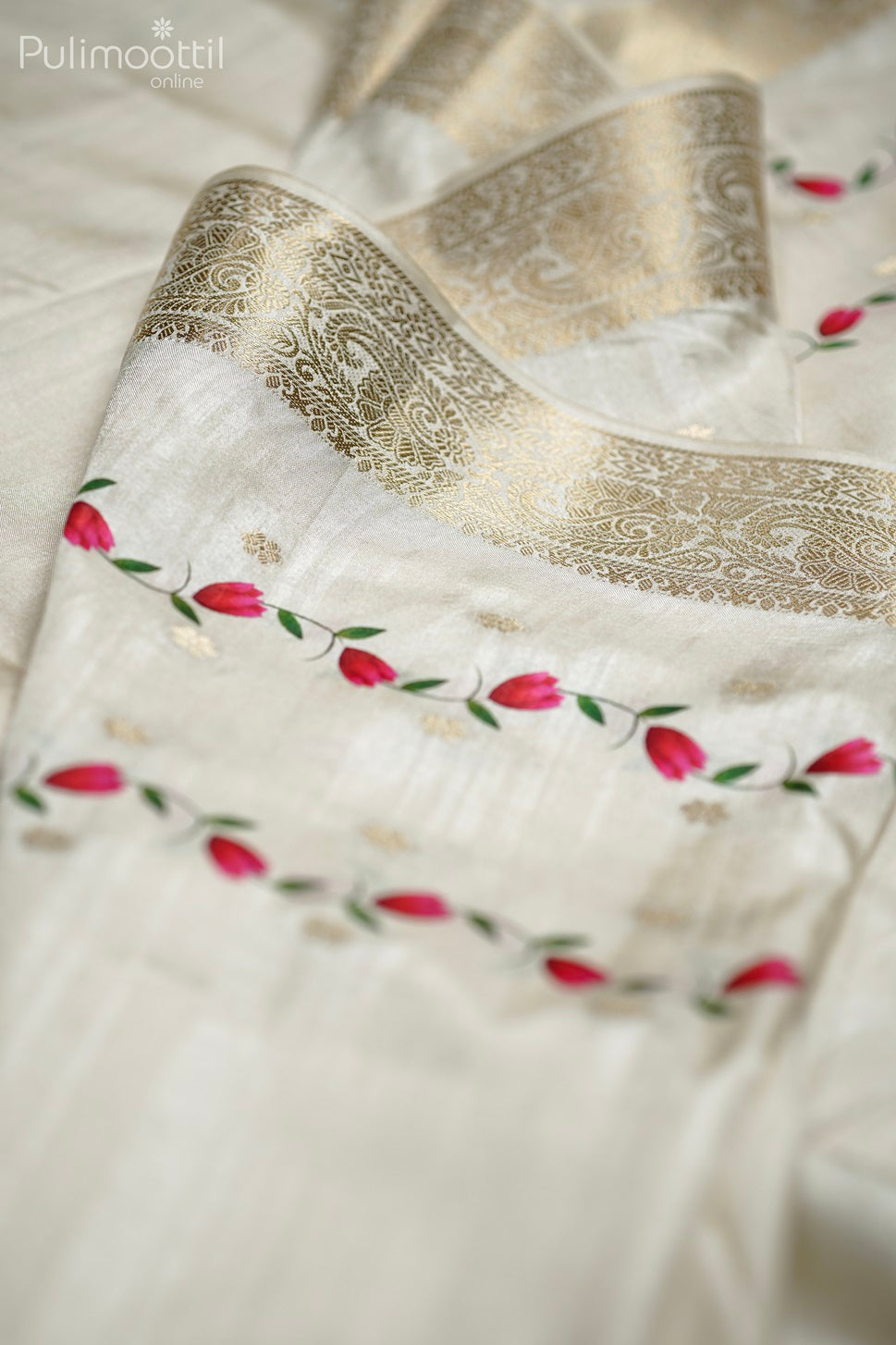 Close-up of off white semi tissue silk fabric with golden zari stripes, floral print motifs, and antique zari border design.