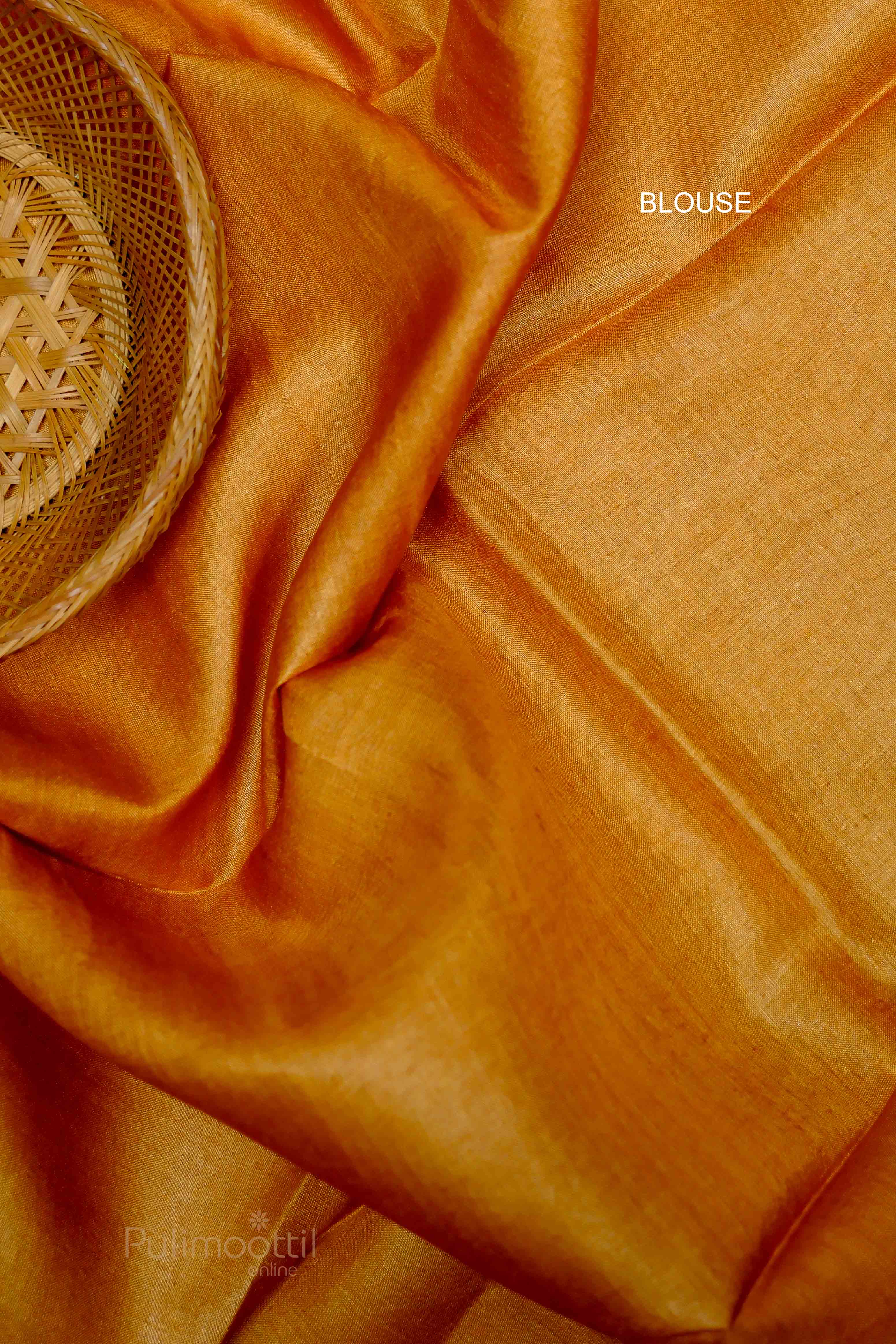 Close-up of a bright orange blouse fabric to match the saree, with smooth texture.