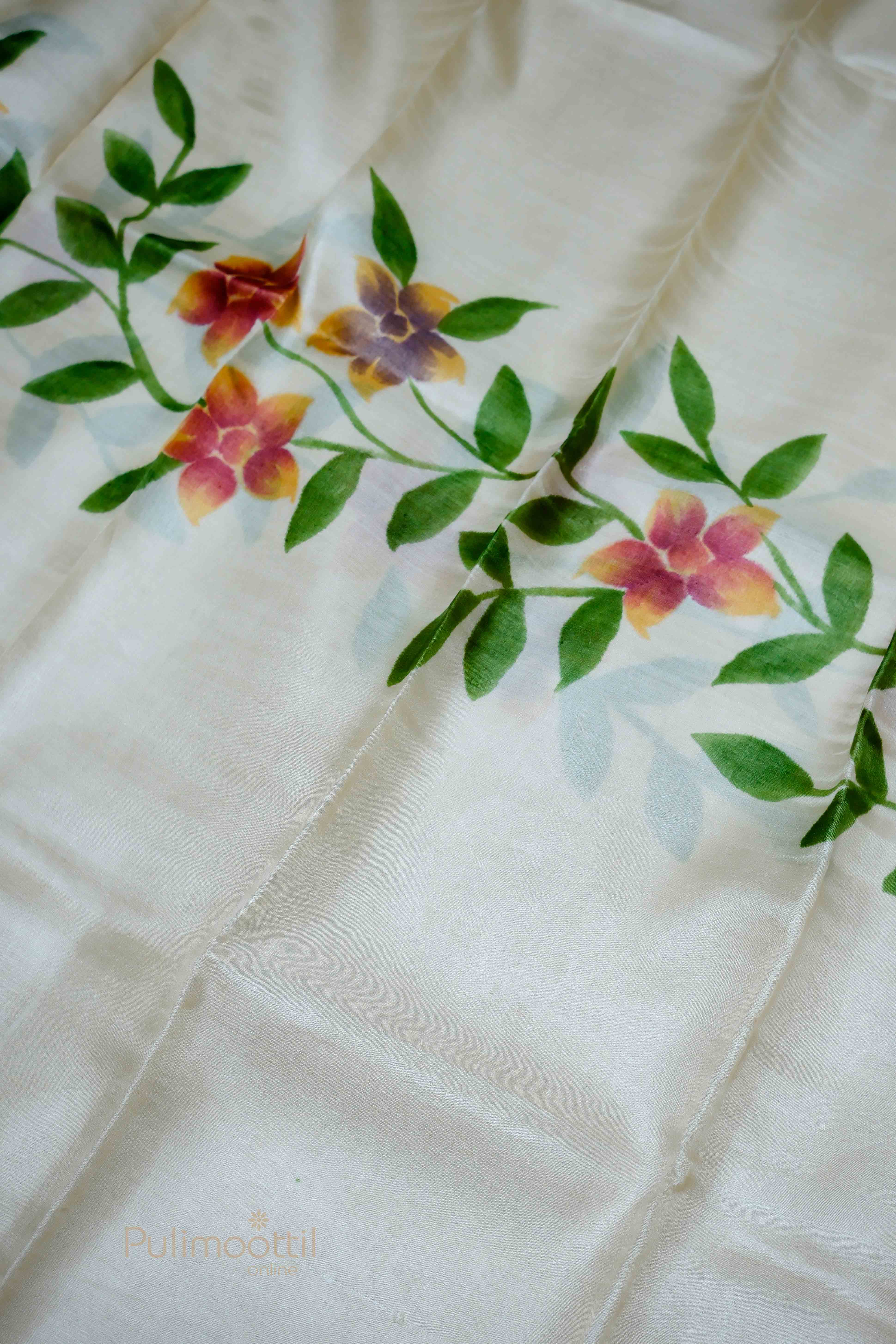 Close-up view of the floral print on the Off-white Tassar saree with vibrant flowers and green leaves.