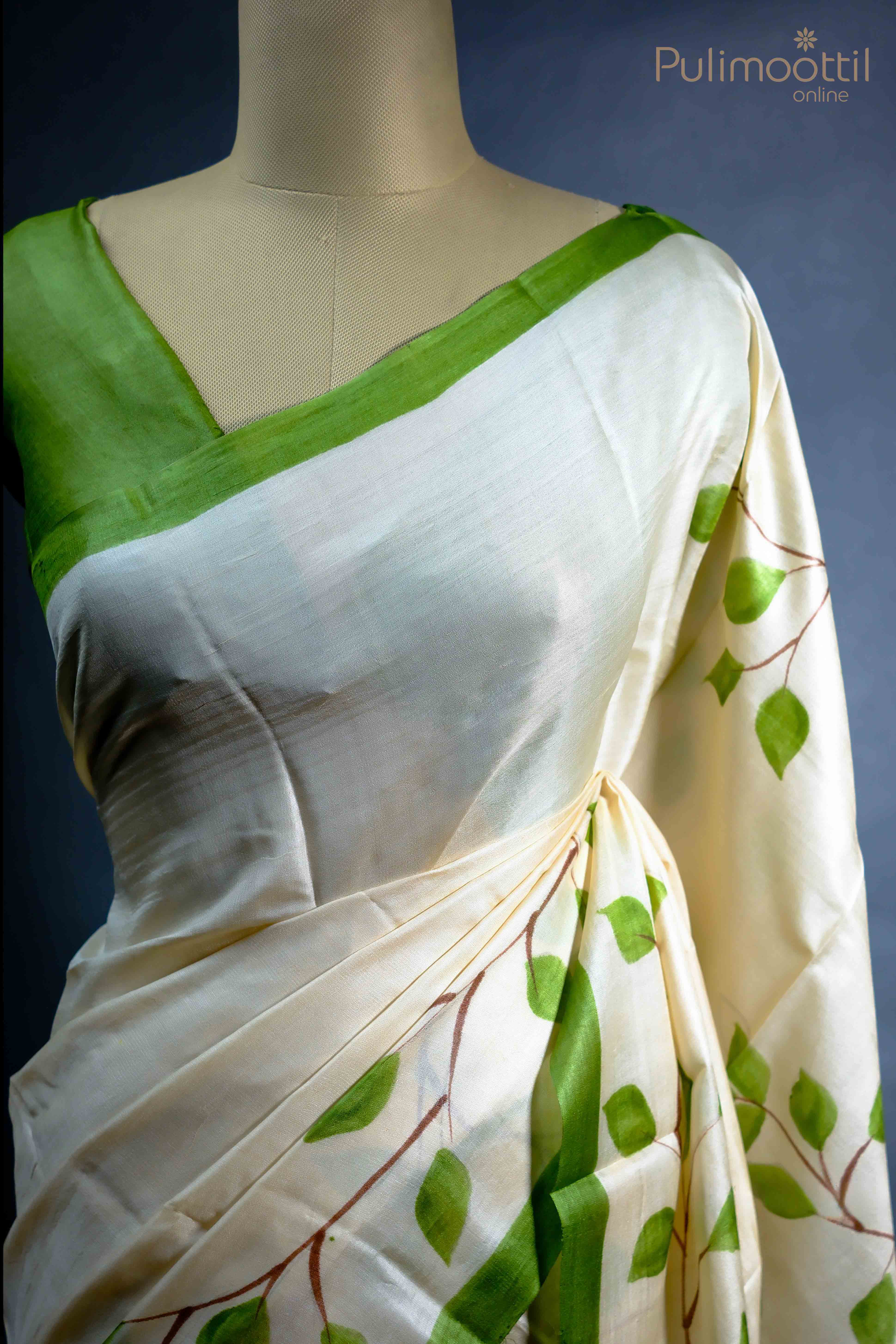 Close-up of the floral print and green border along the off-white Tassar Onam saree, highlighting the intricate design.