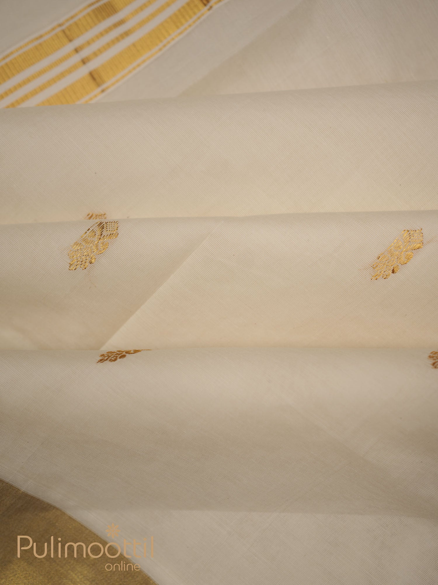 Off-white Kerala power‑loom kasavu saree with scattered golden zari buttas on the body and a golden-stripe kasavu border, folded to highlight its lustrous texture.