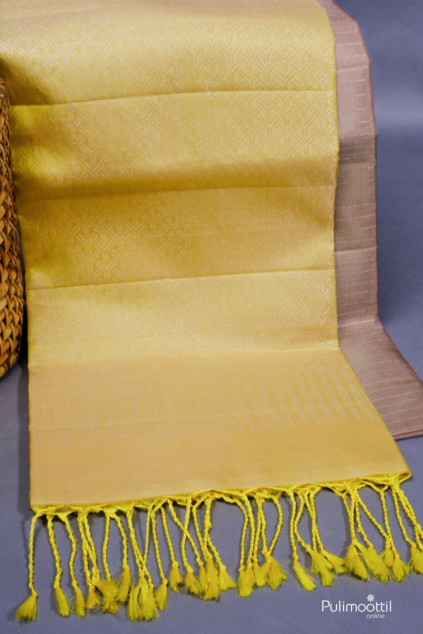 Close-up of yellow pallu with tassels and jacquard detailing on a gray Kanchipuram silk saree