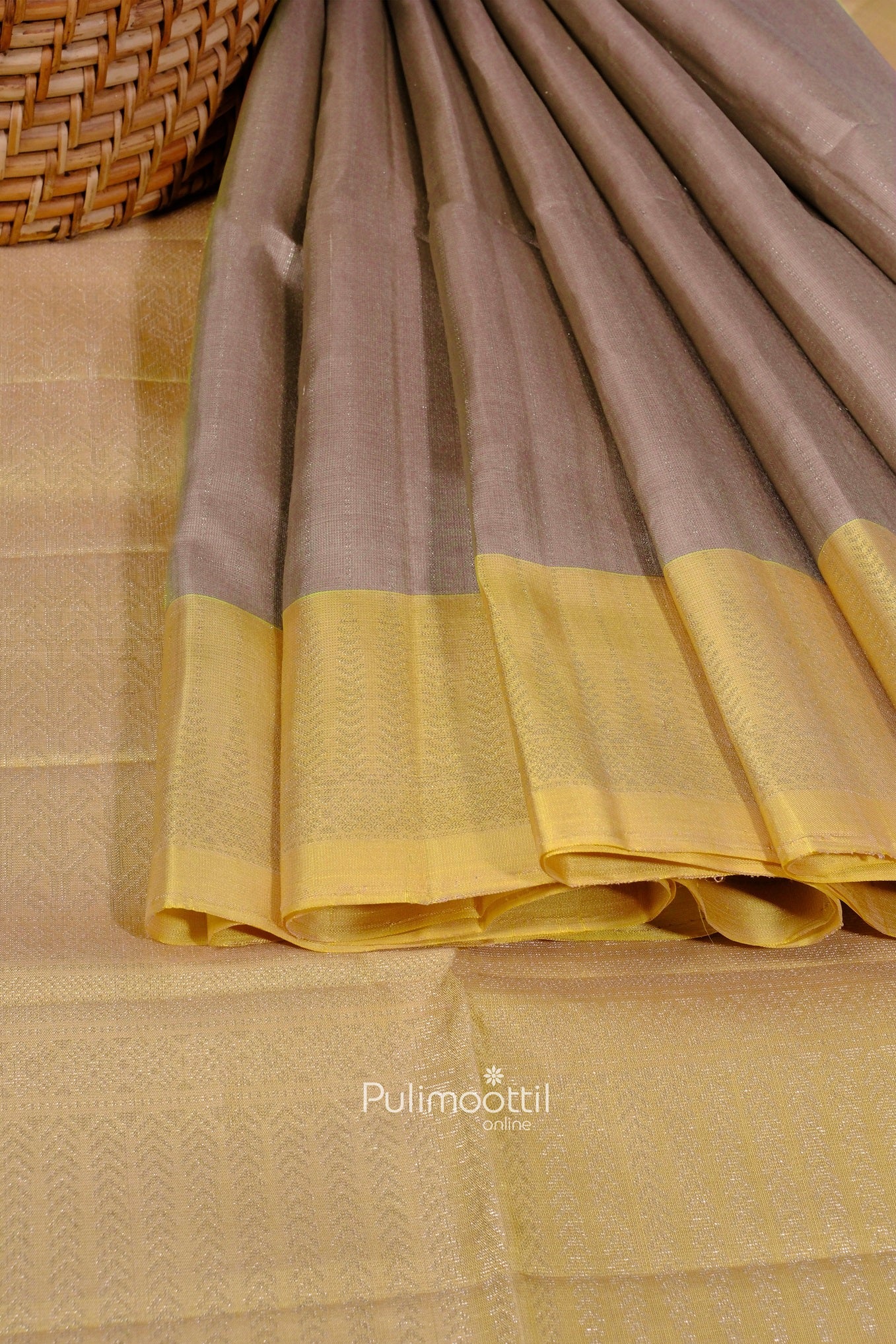 Folded oyster gray Kanchipuram silk saree with yellow border and subtle woven patterns