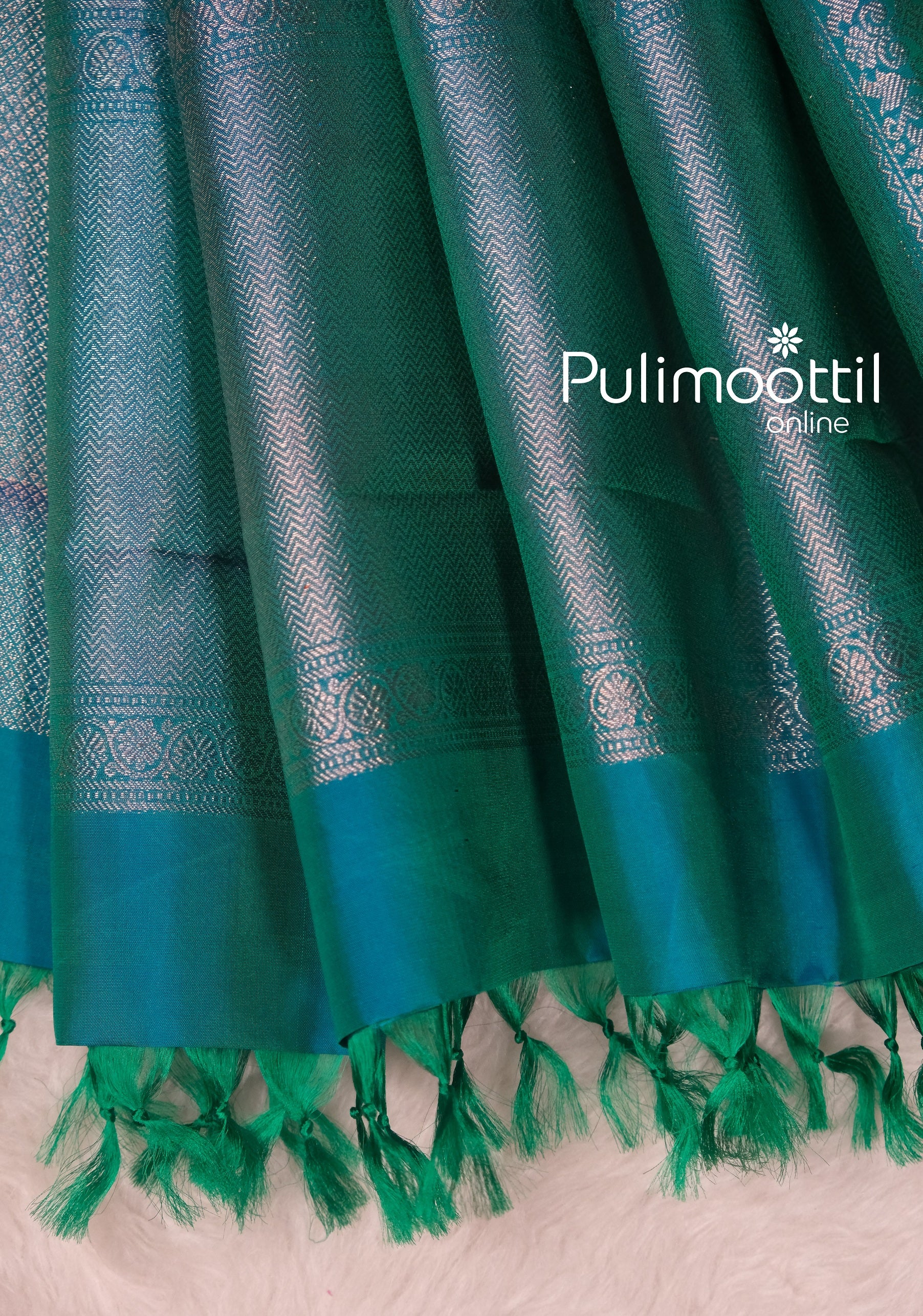 Zoomed-in detailing of silver zari on a peacock green Kanchipuram saree, crafted for brides and women looking to buy traditional silk sarees online.