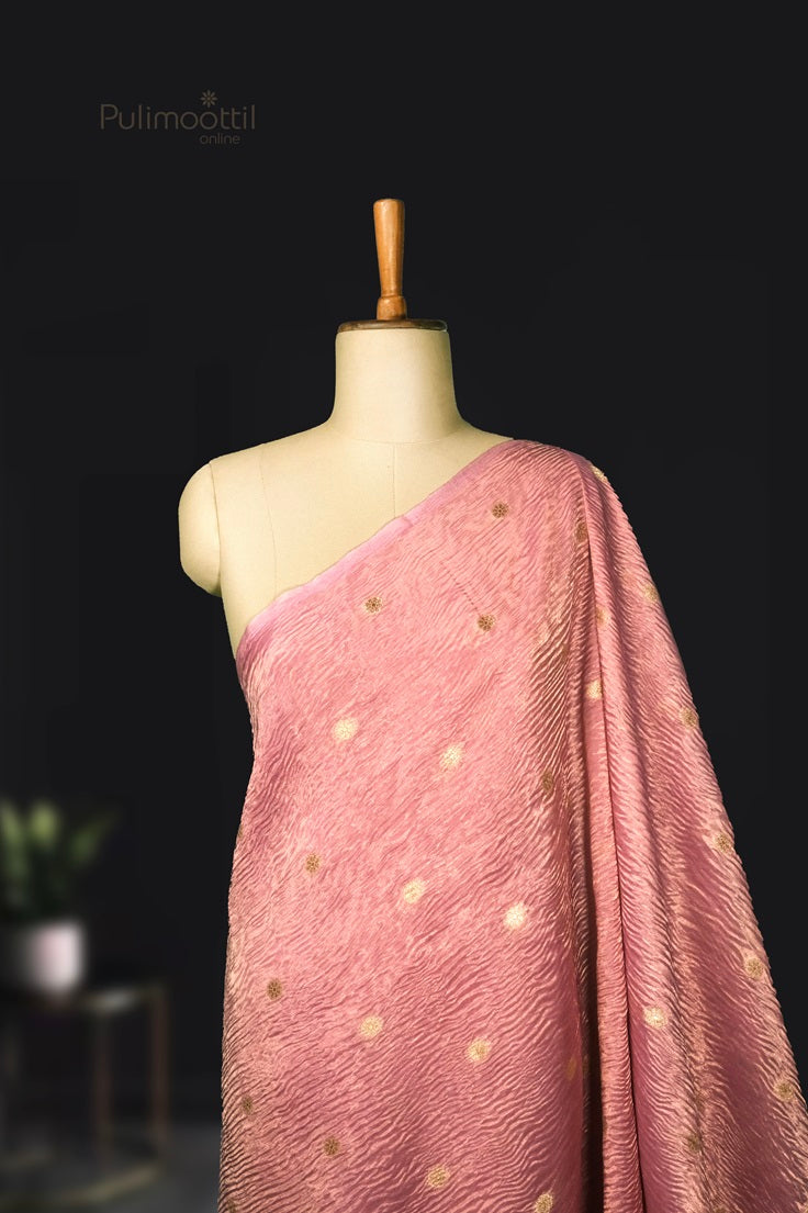 Close-up of crushed organza saree fabric highlighting its translucent texture and gentle pastel pink tone