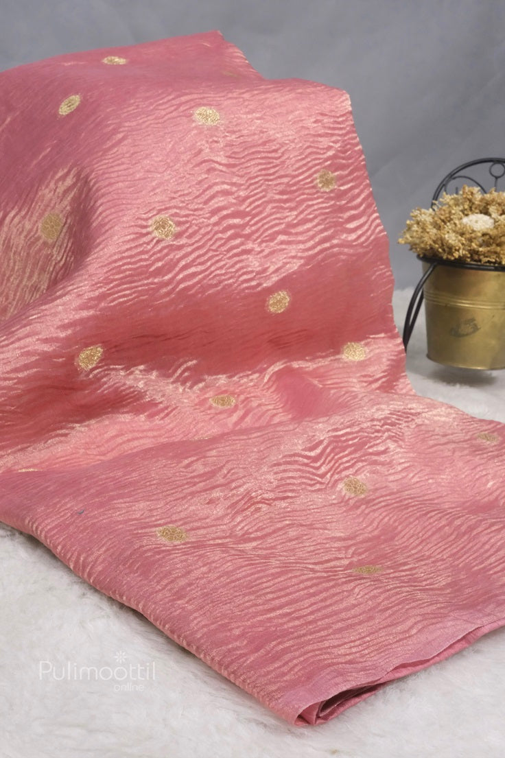 Pastel pink crushed organza saree draped on a mannequin with subtle embroidery and sheer texture