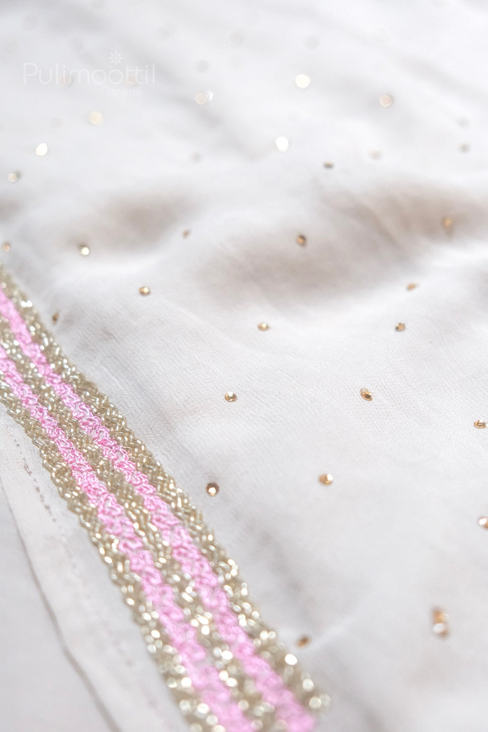 Blouse fabric in plain ivory white with scattered golden sequin dots and pink-gold embroidered border detail