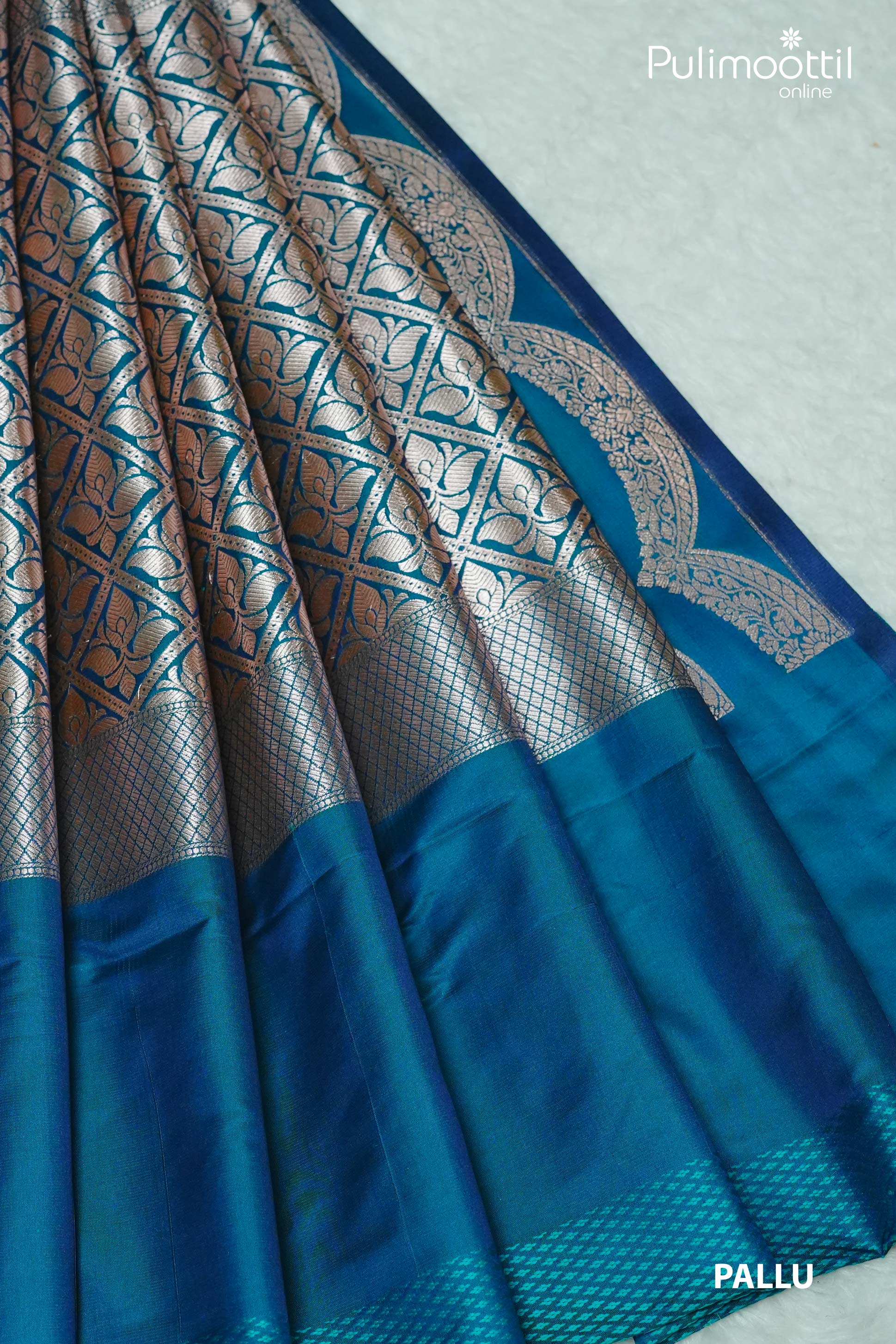 Peacock blue Banarasi silk saree with silver zari designer pallu featuring floral grid motifs and scalloped border – Pulimoottil Silks