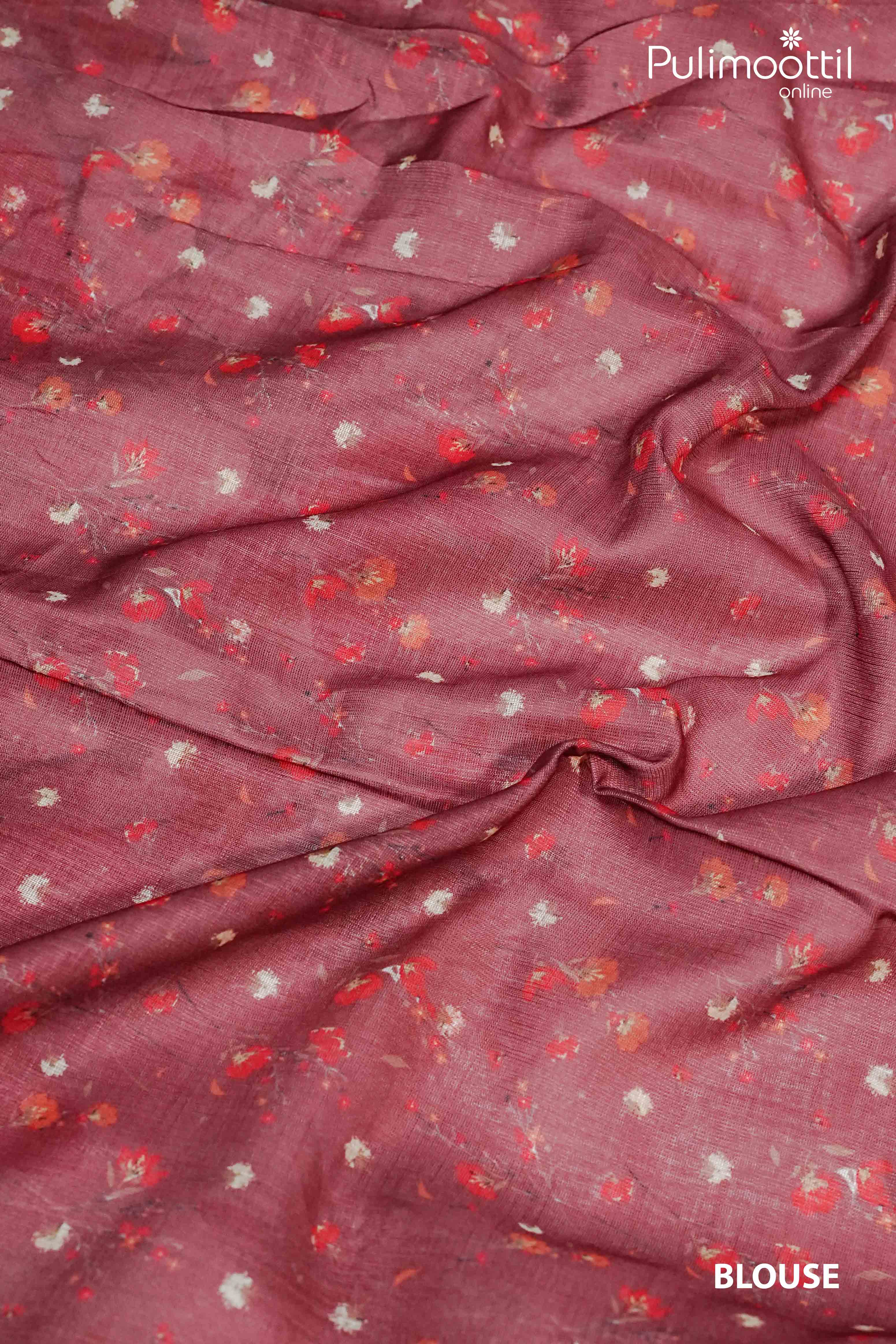 Blouse fabric for pink semi linen saree in dusty rose shade with subtle scattered floral motifs in red, peach, and white on soft woven texture.