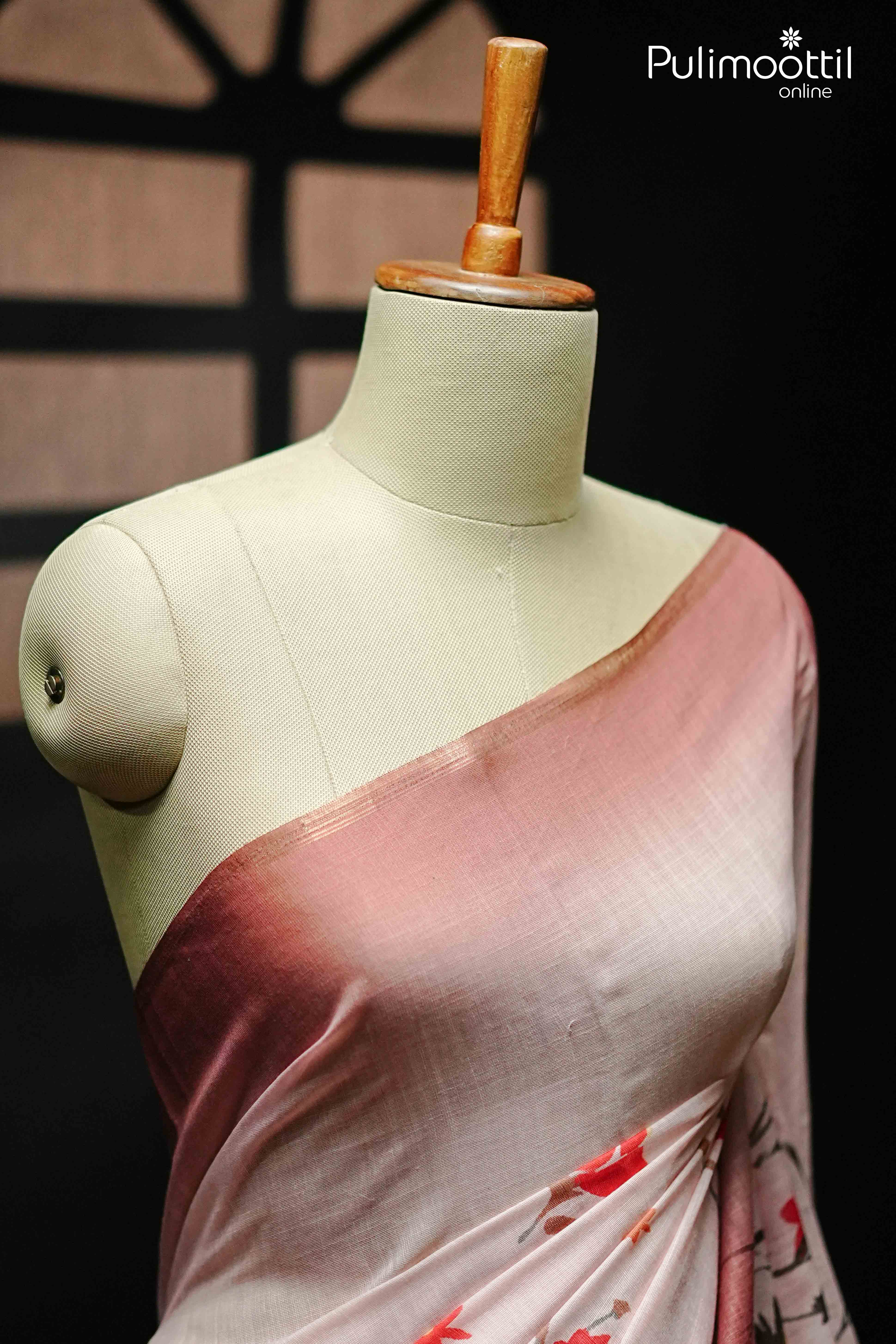 Close-up of pink semi linen saree draped on mannequin shoulder, featuring soft rose-to-mauve gradient and a hint of red floral print on pleats.