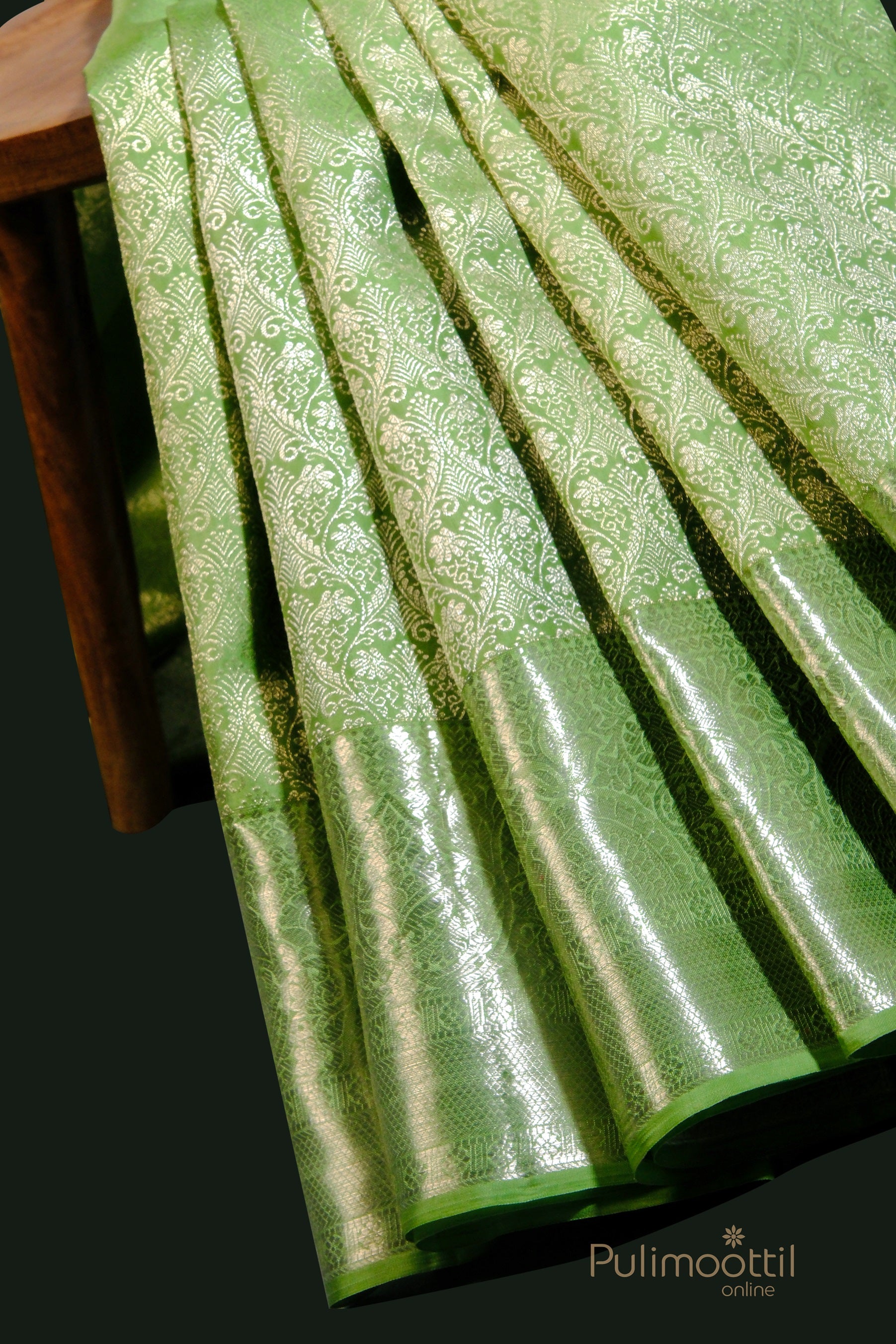 Elegant pista green Kanchipuram bridal silk saree with detailed zari work and folded pleats