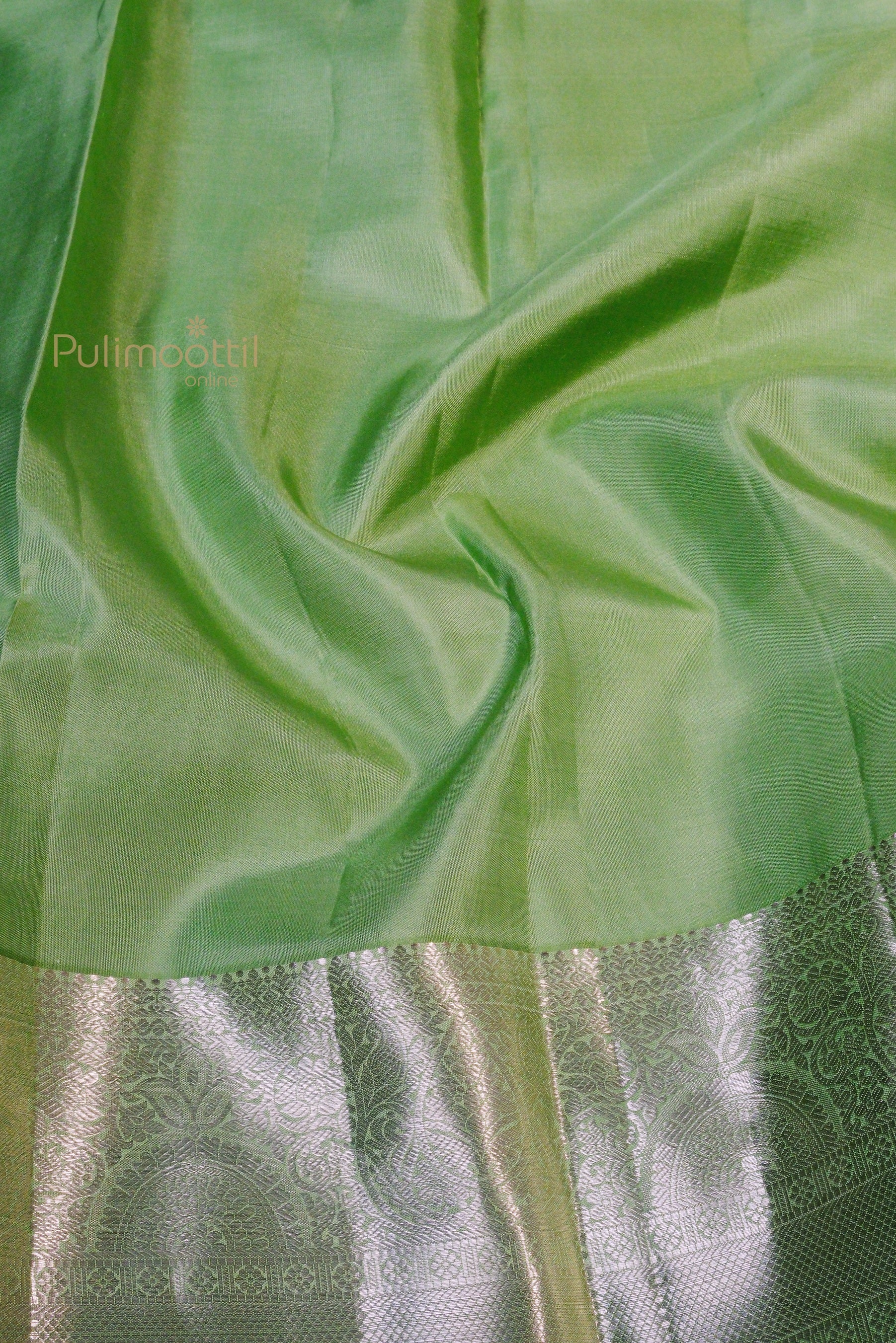 Soft silk texture of pista green Kanchipuram saree with shimmering silver zari highlights