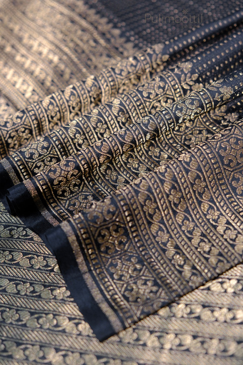 Traditional Indian silk saree border featuring elaborate gold zari work with geometric and floral embroidery patterns