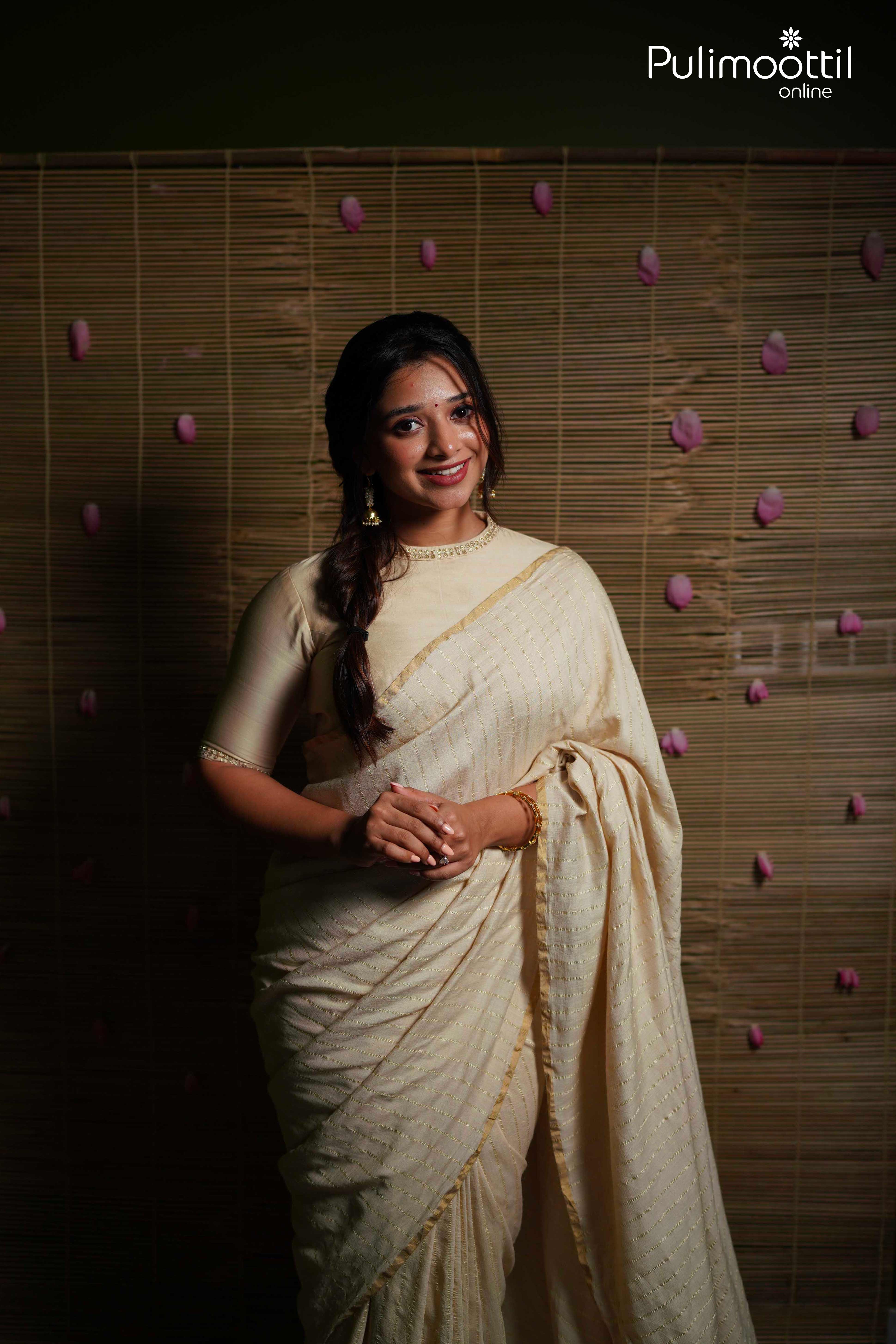 Cream pure silk tissue saree with silver zari stripes and thin gold border, detailed close-up of fabric drape and texture.