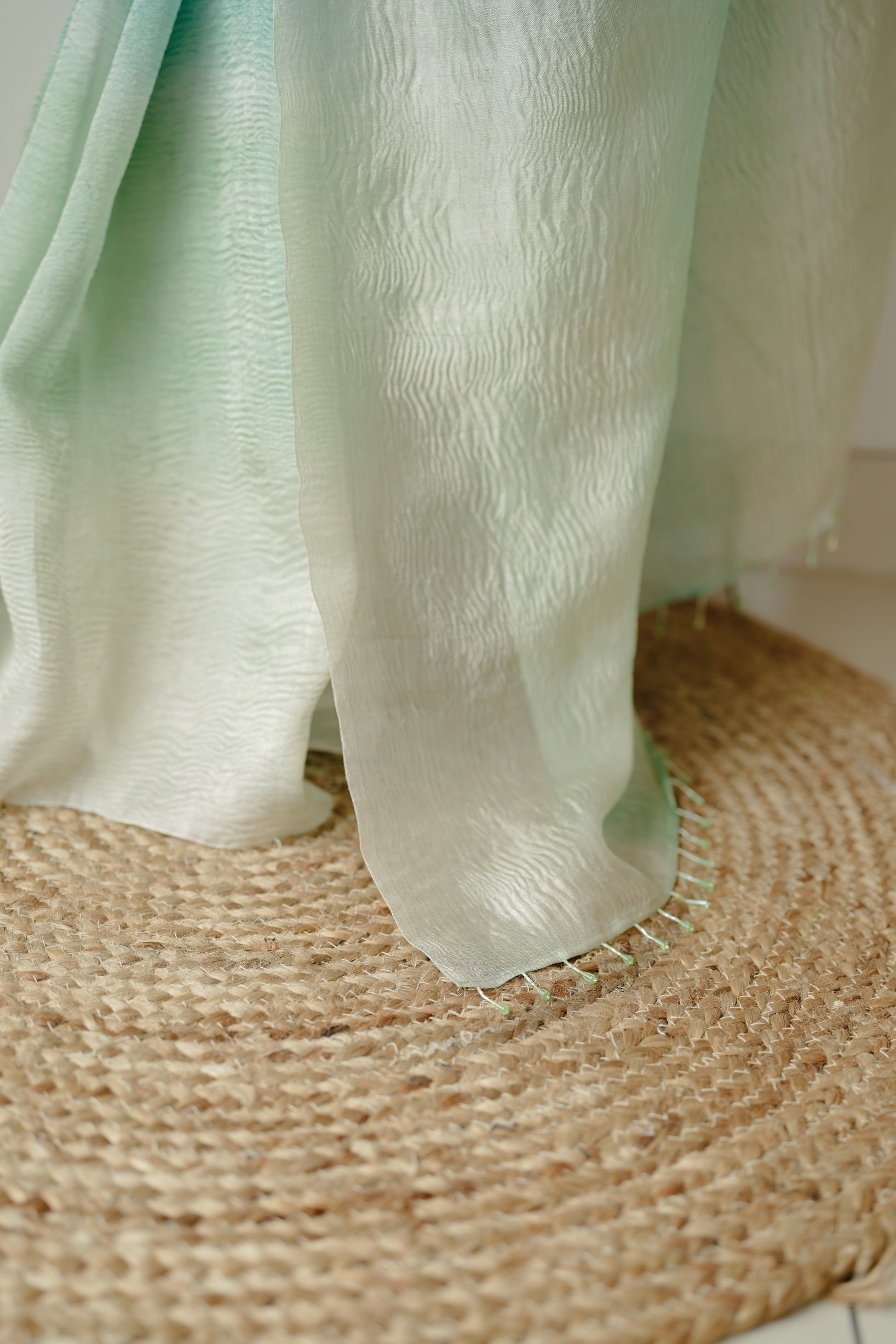 Close-up of the woman holding the pallu of her ombre blue Benarasi crush saree, highlighting the light texture and gradient fabric details.
