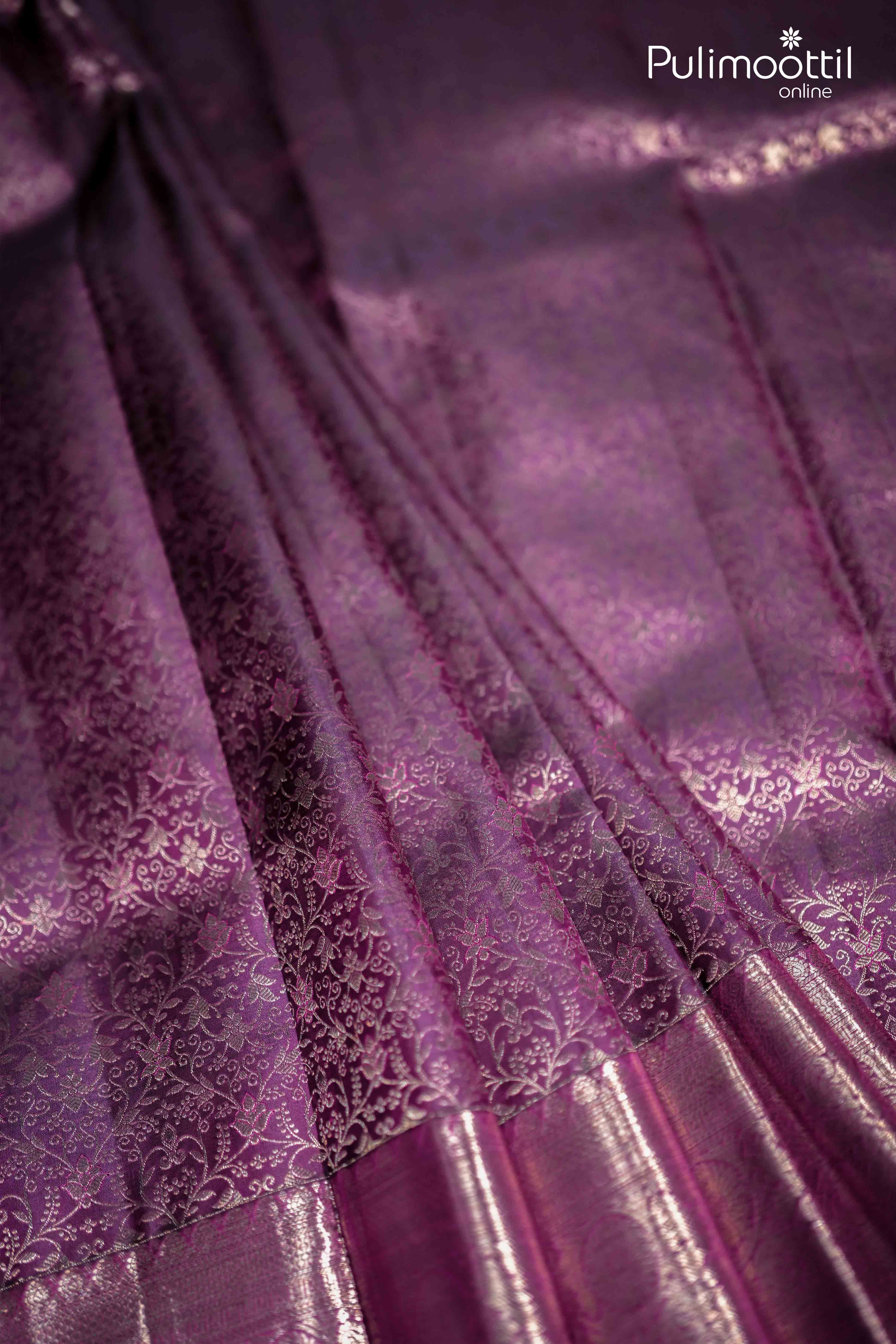 Detailed view of purplle plum Kanchipuram saree body featuring rich copper zari floral creeper motifs and a lustrous finish, perfect for bridal wear and Onam festivities.