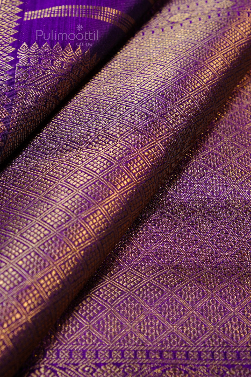 Close-up of pure Kanchipuram silk saree in ripe plum shade with intricate gold zari weave