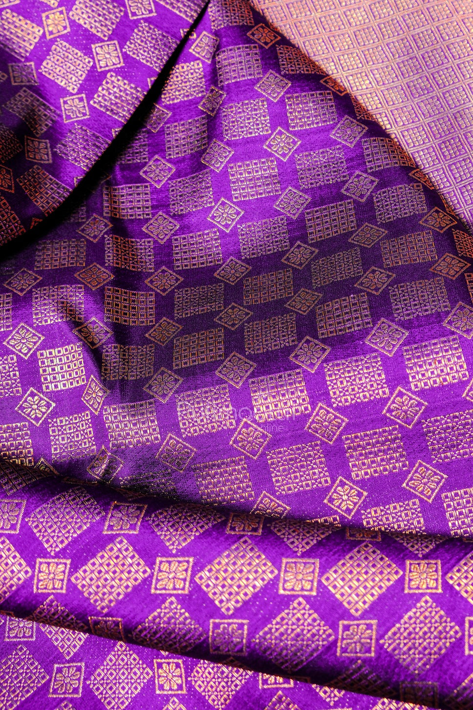 Folded ripe plum Kanchipuram bridal saree showcasing traditional gold floral motifs