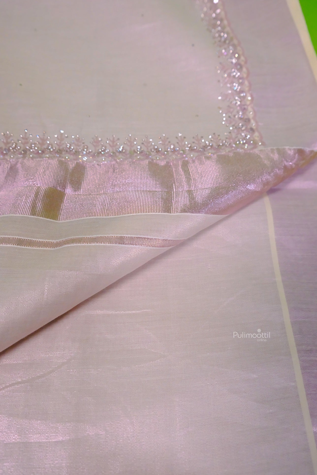 Full view of rose gold Kerala tissue saree with traditional handwoven details and shimmering pallu