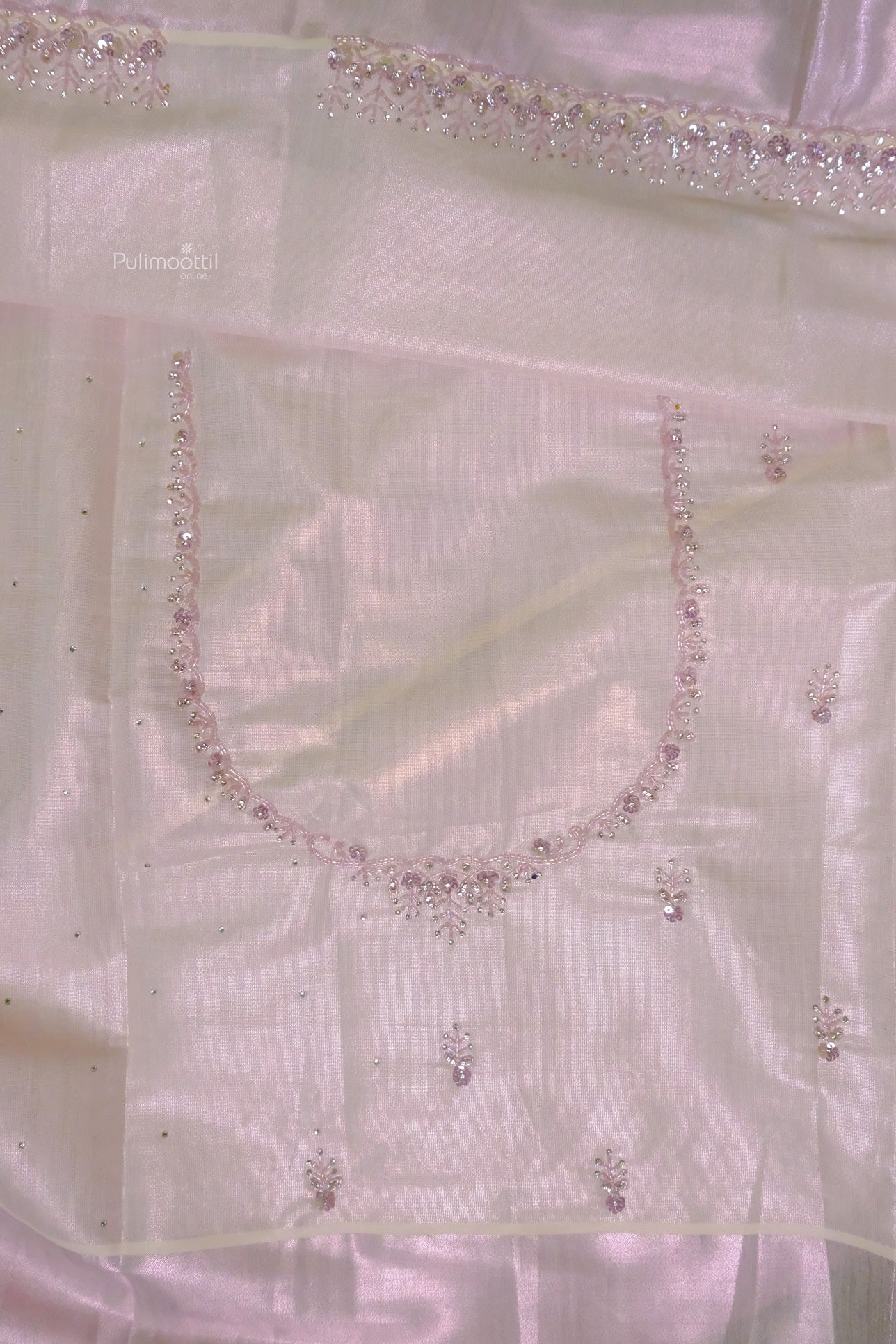 Back portion of matching blouse piece with subtle scattered bead embellishments on rose gold tissue fabric