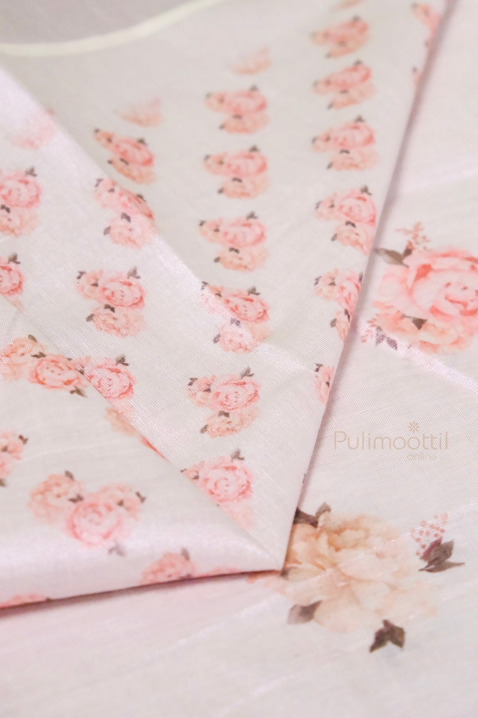 Detailed view of Kerala tissue saree border with metallic pink zari, cream stripes, and multicolored tassels with floral print.