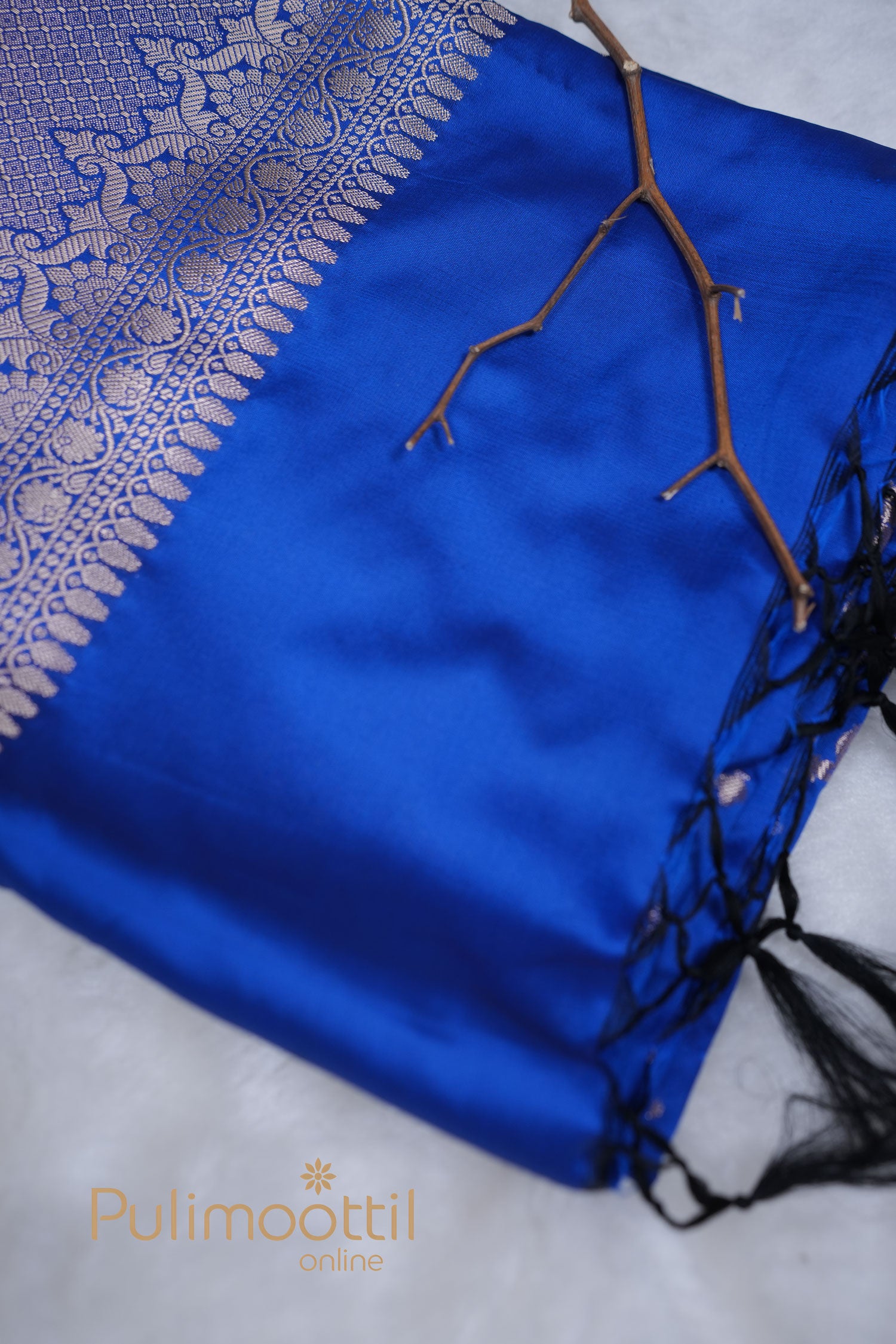 Close-up of royal blue semi silk saree showing smooth texture and zari details.