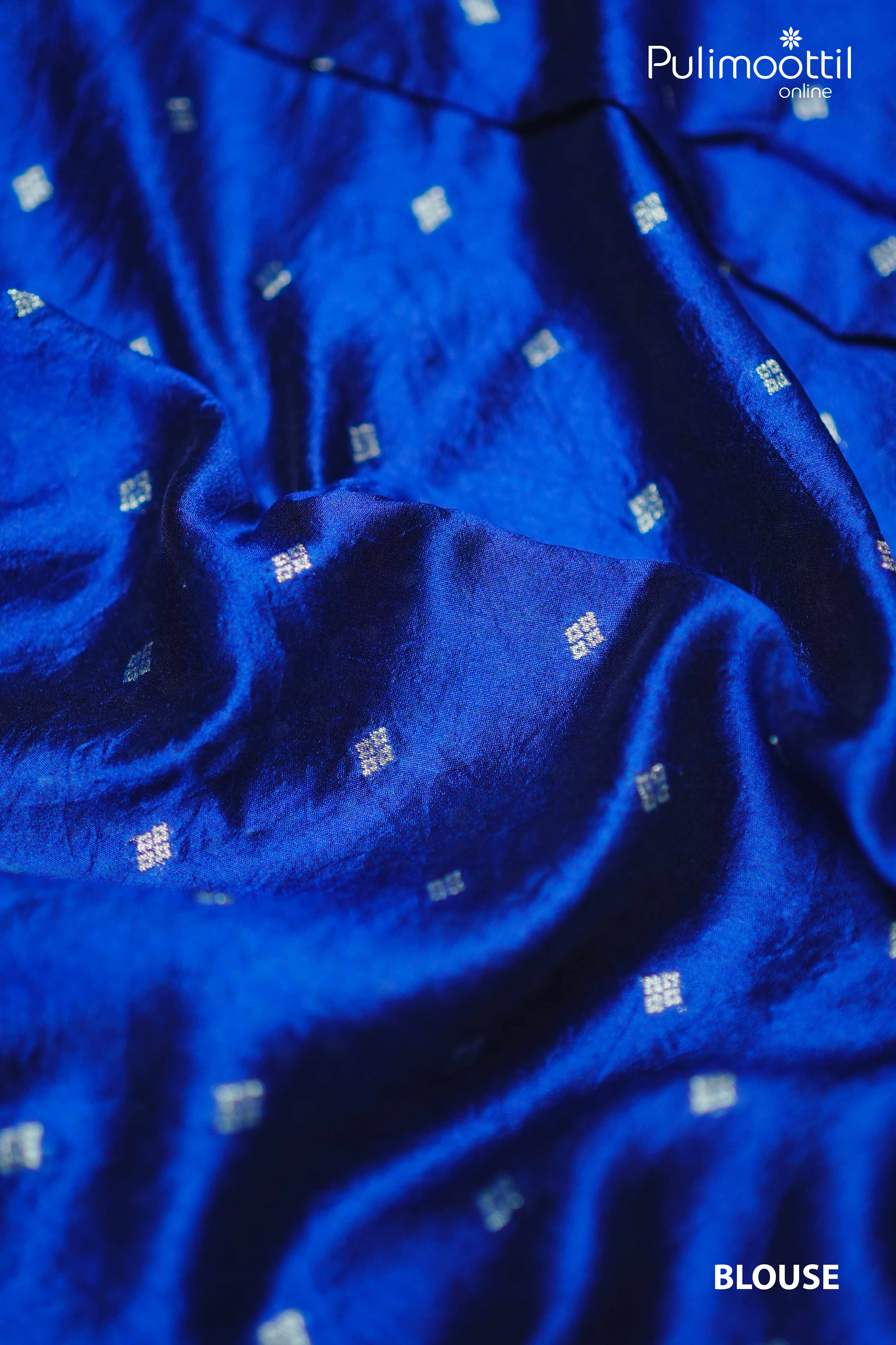 Close-up of matching royal blue blouse fabric with small white woven motifs on smooth Tussar silk.