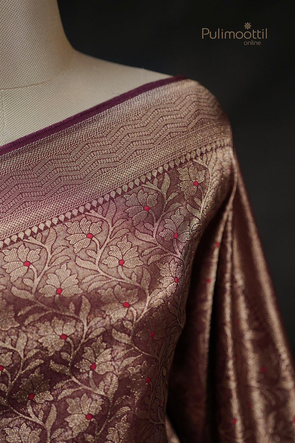 Close-up of the Saree Border and Body on a mannequin, highlighting the bold gold zari border and the red-dotted floral pattern.