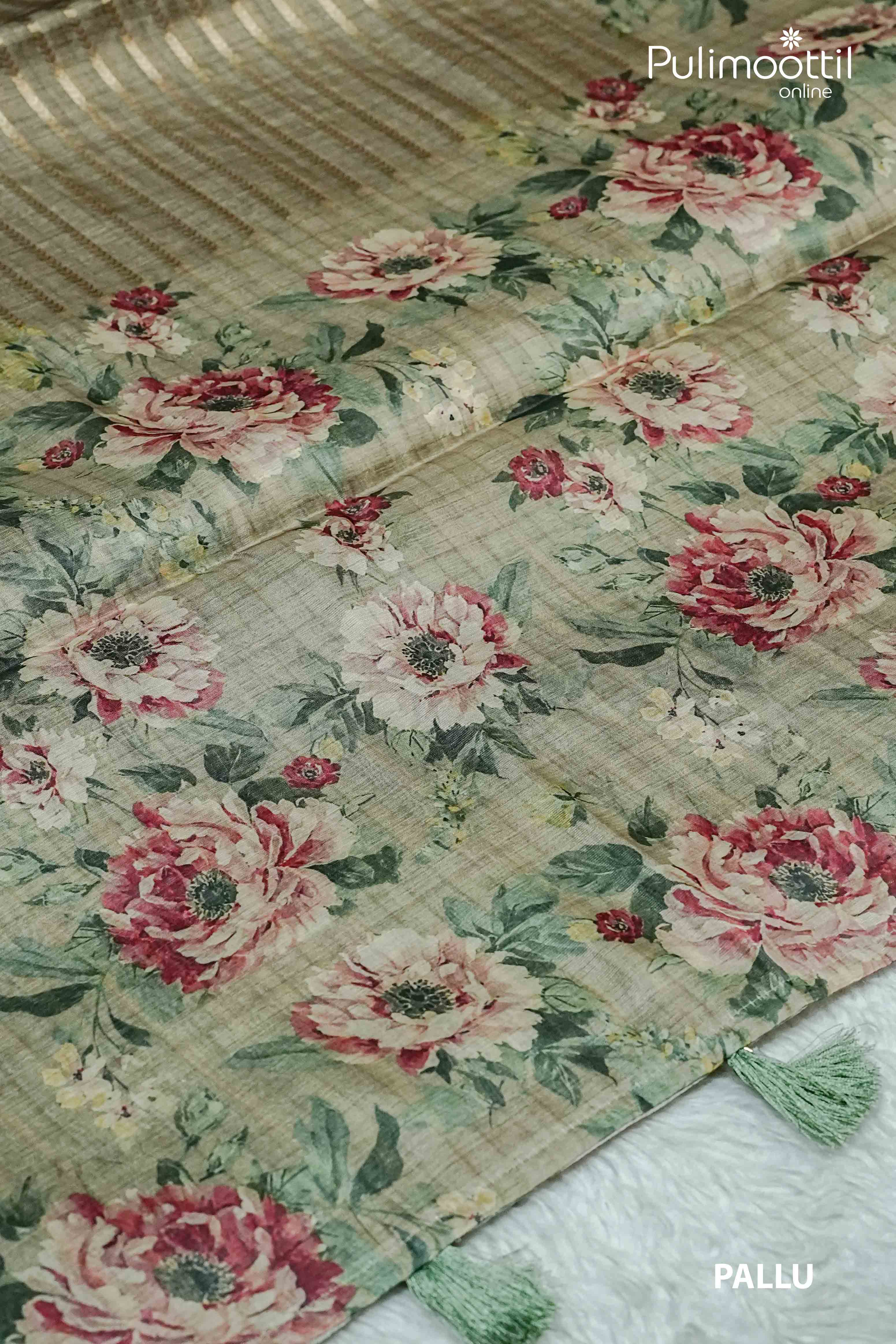 Behr green organza saree pallu featuring bold floral bouquet print and soft green tassels, ideal for festive occasions like Onam.