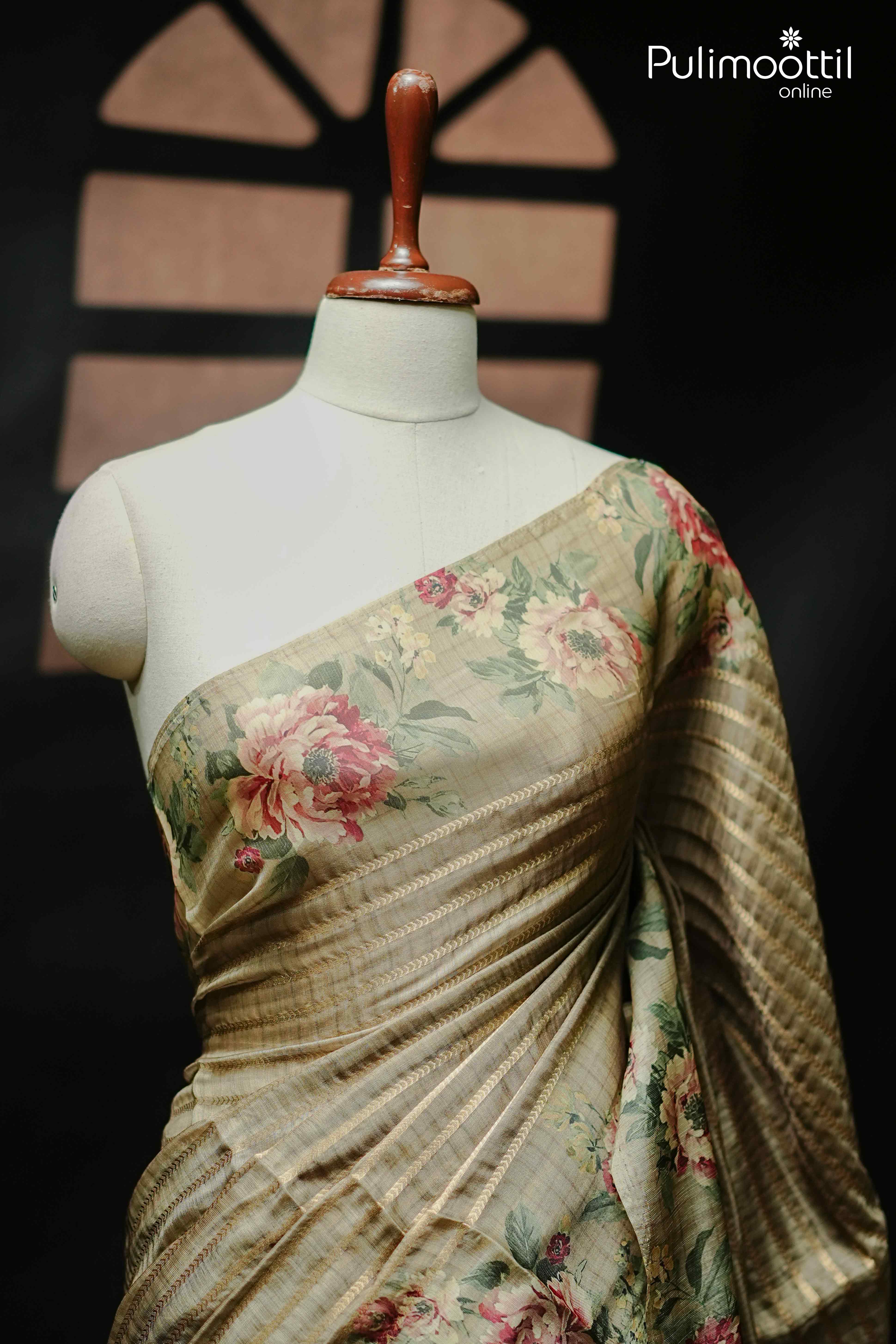 Front view of Secret Meadow Behr green organza saree draped on a mannequin, showcasing floral printed border and elegant golden zari lines—perfect for traditional celebrations like Onam.