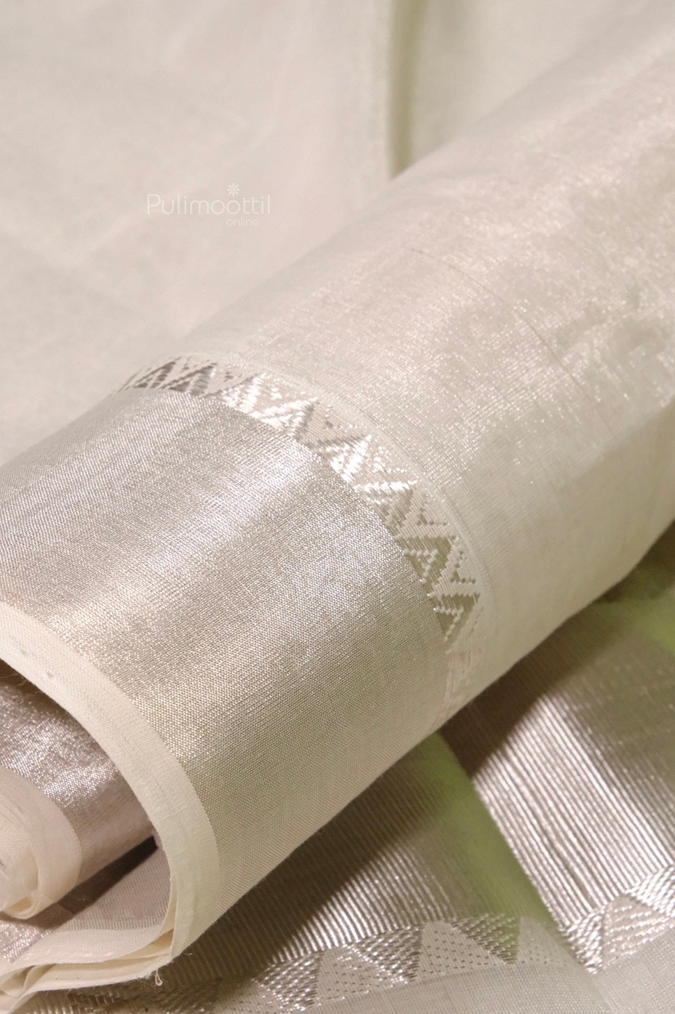 Rolled handloom Kerala cotton saree featuring elegant silver zari work on pallu and borders