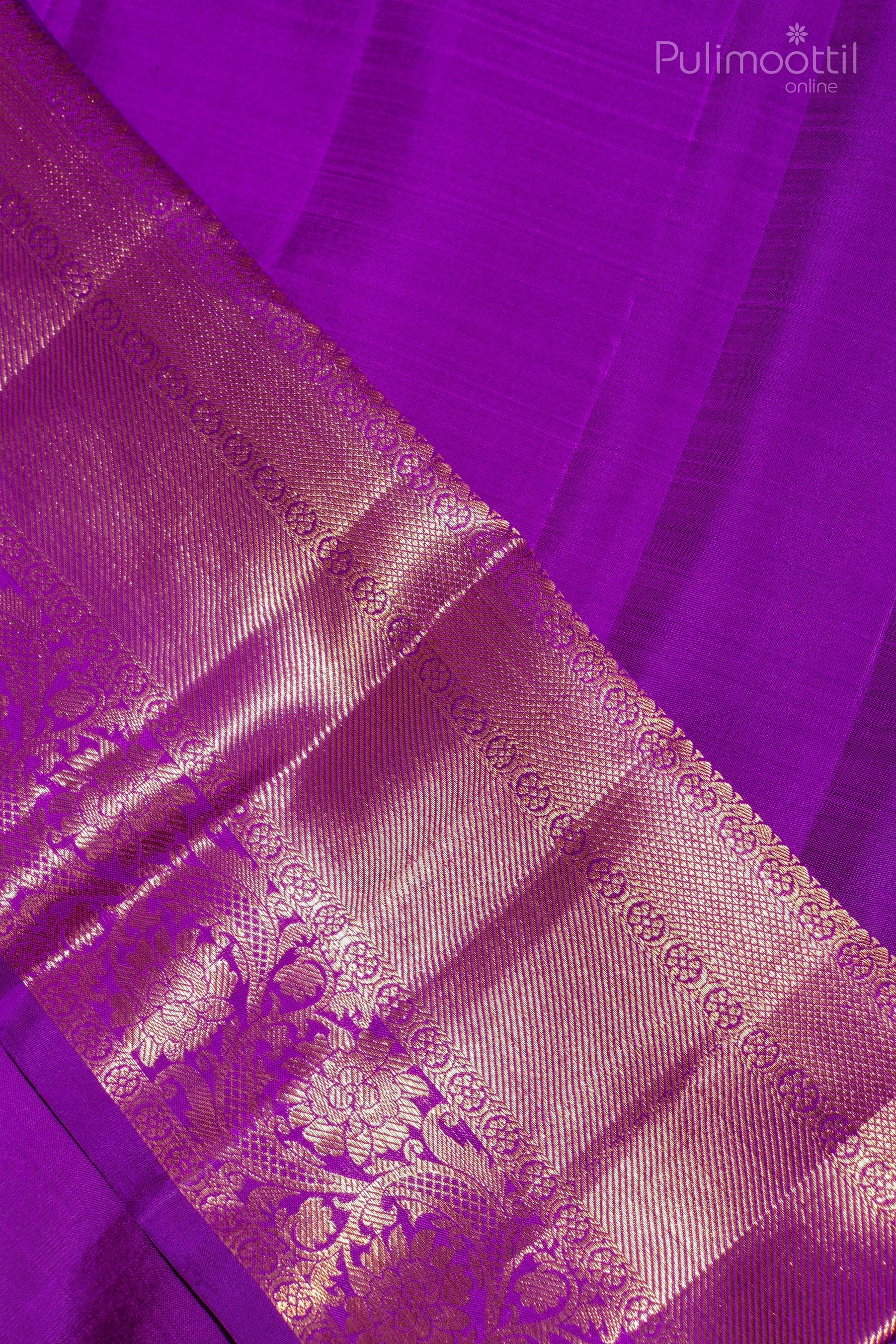 Elegant violet Kanchipuram saree with a broad golden zari border and subtle striped texture.