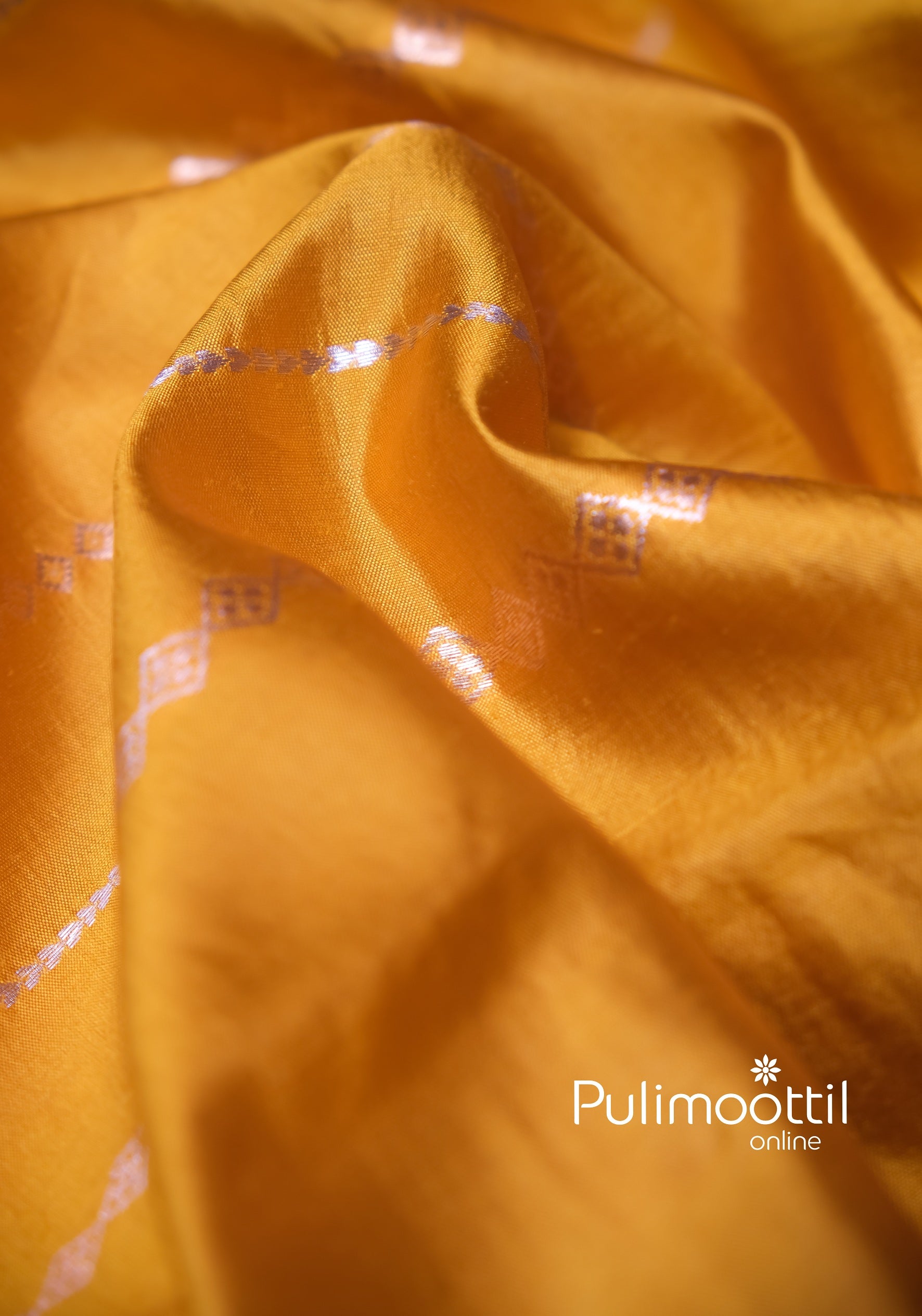 Close-up of yellow silk saree fabric with diamond zari motifs, ideal for festive Haldi wedding wear