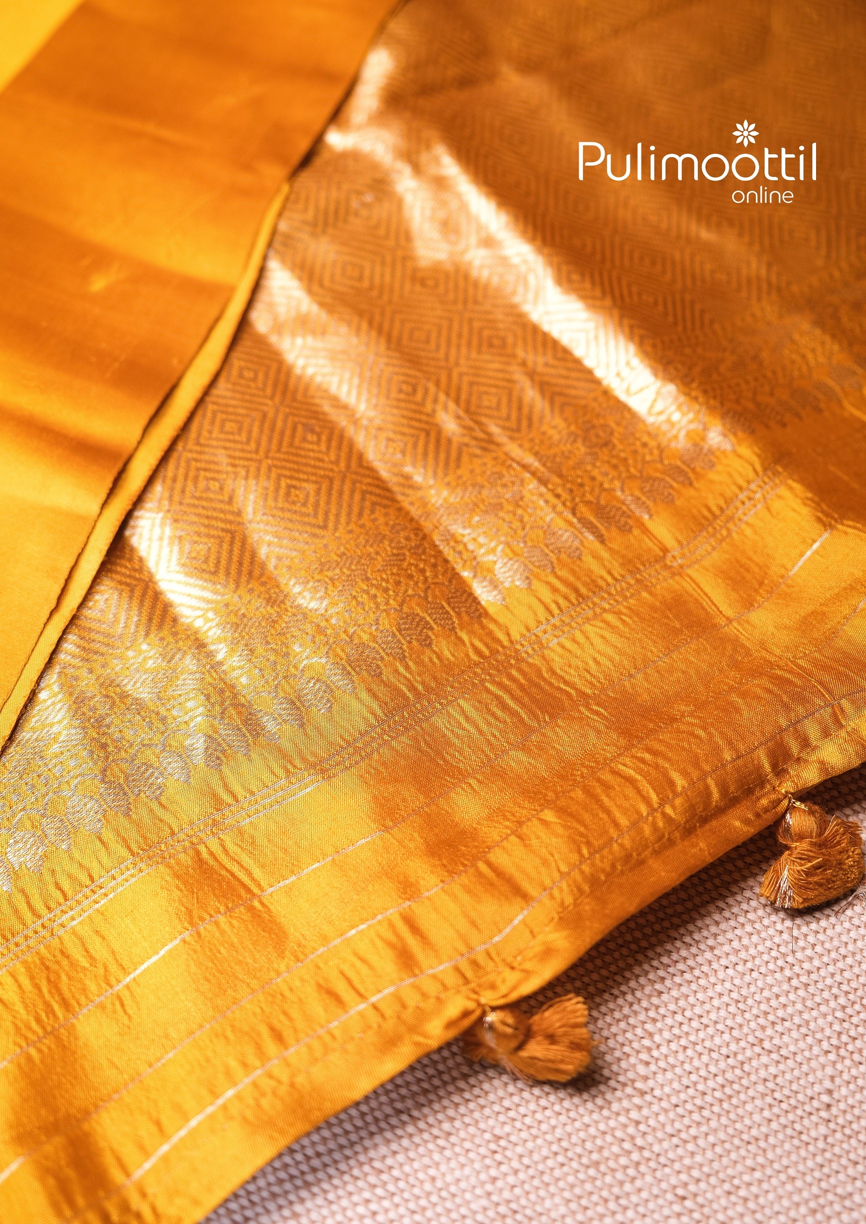 Richly woven golden zari pallu of yellow silk saree, adorned with intricate motifs and tassels – perfect for bridal Haldi event